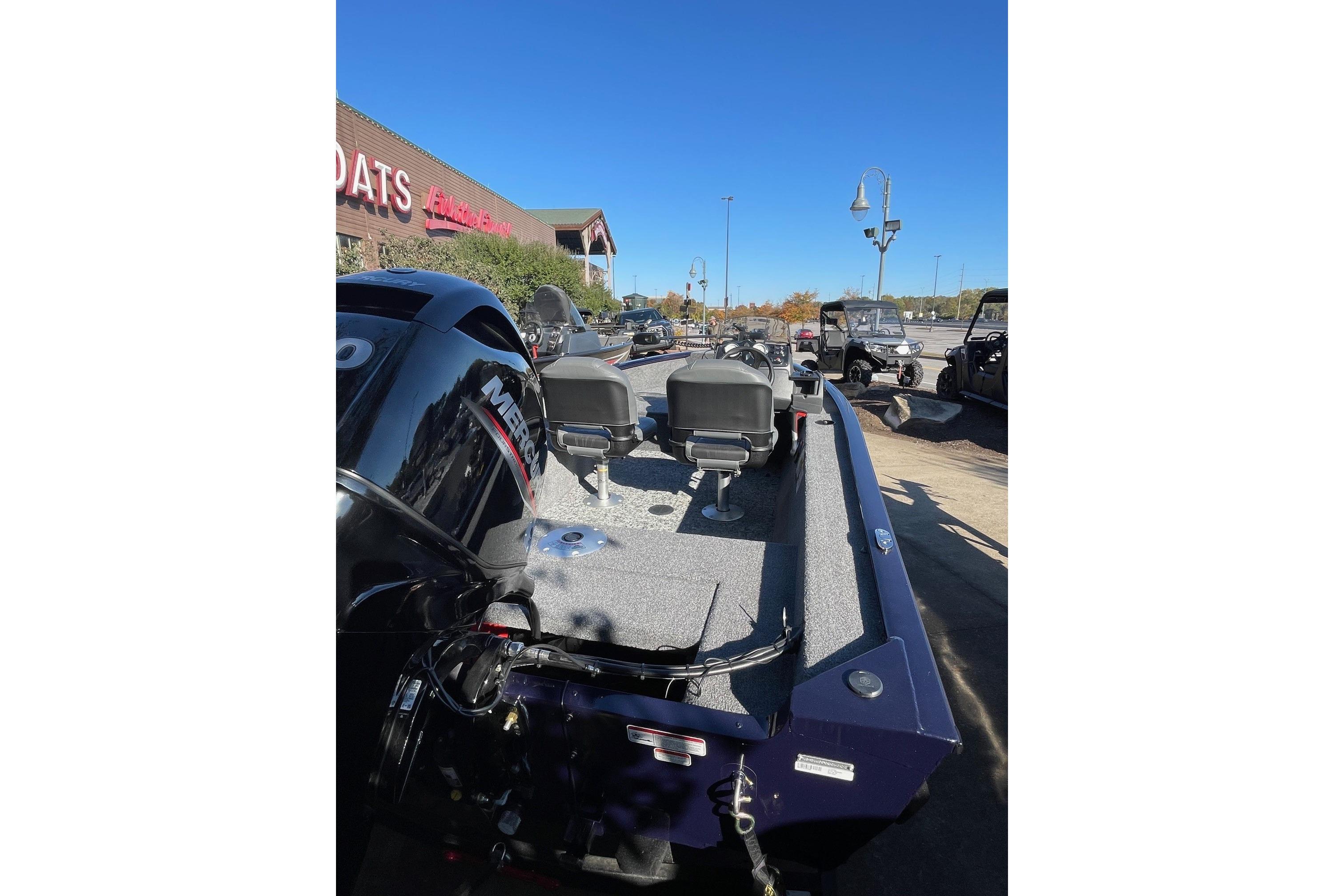 2026 Tracker Super Guide V-16 SC boat with Mercury engine, parked outdoors.