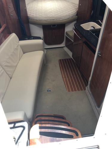 Interior of a 2008 Four Winns V338 with a sofa, carpet, and kitchenette.