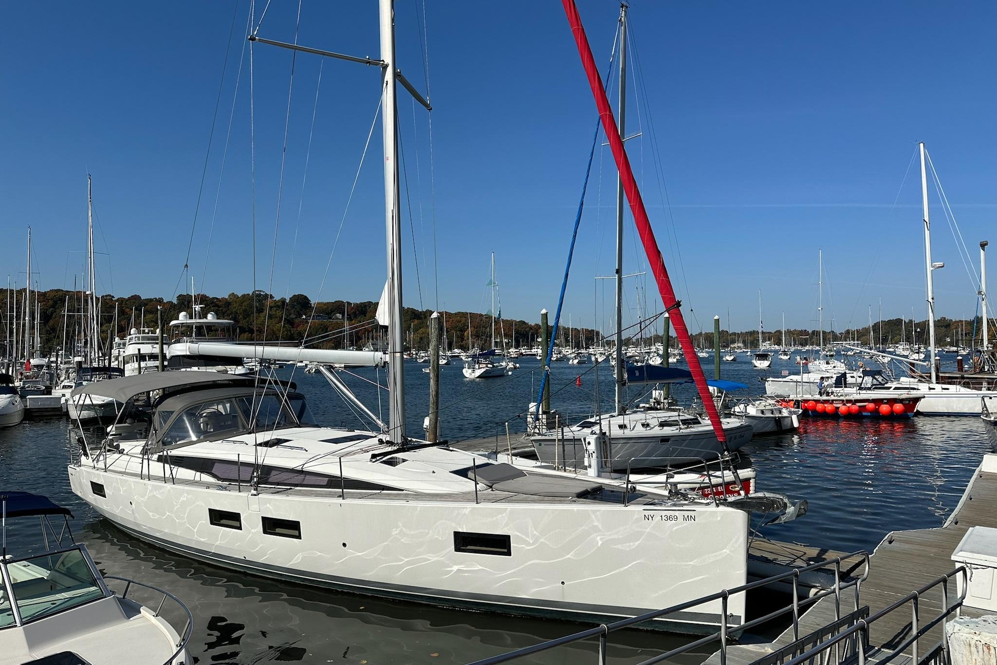 2018 Jeanneau 51 sailboat docked in a marina under clear blue skies.