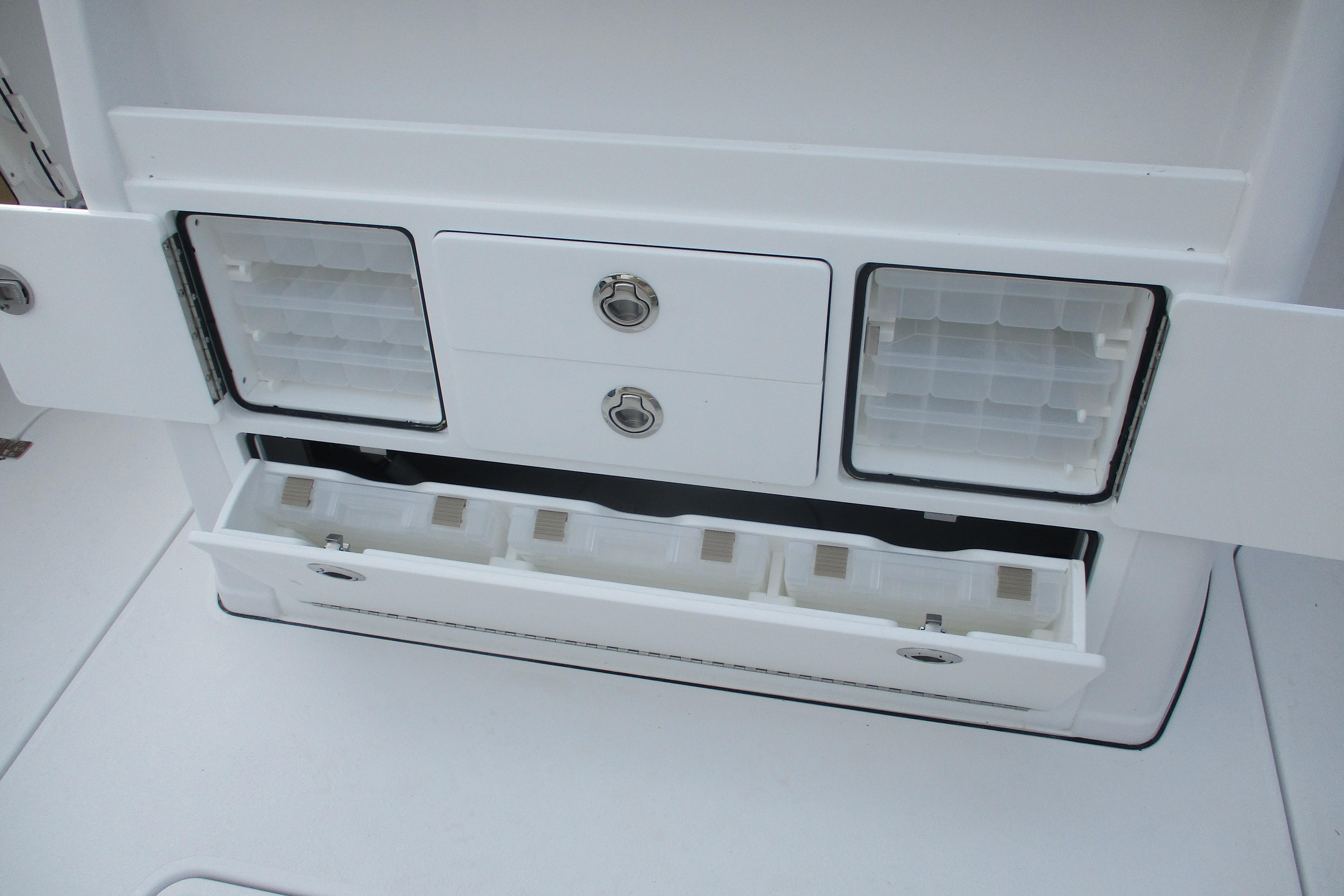 2026 Sportsman Open 302 Center Console storage compartments with organized tackle boxes.