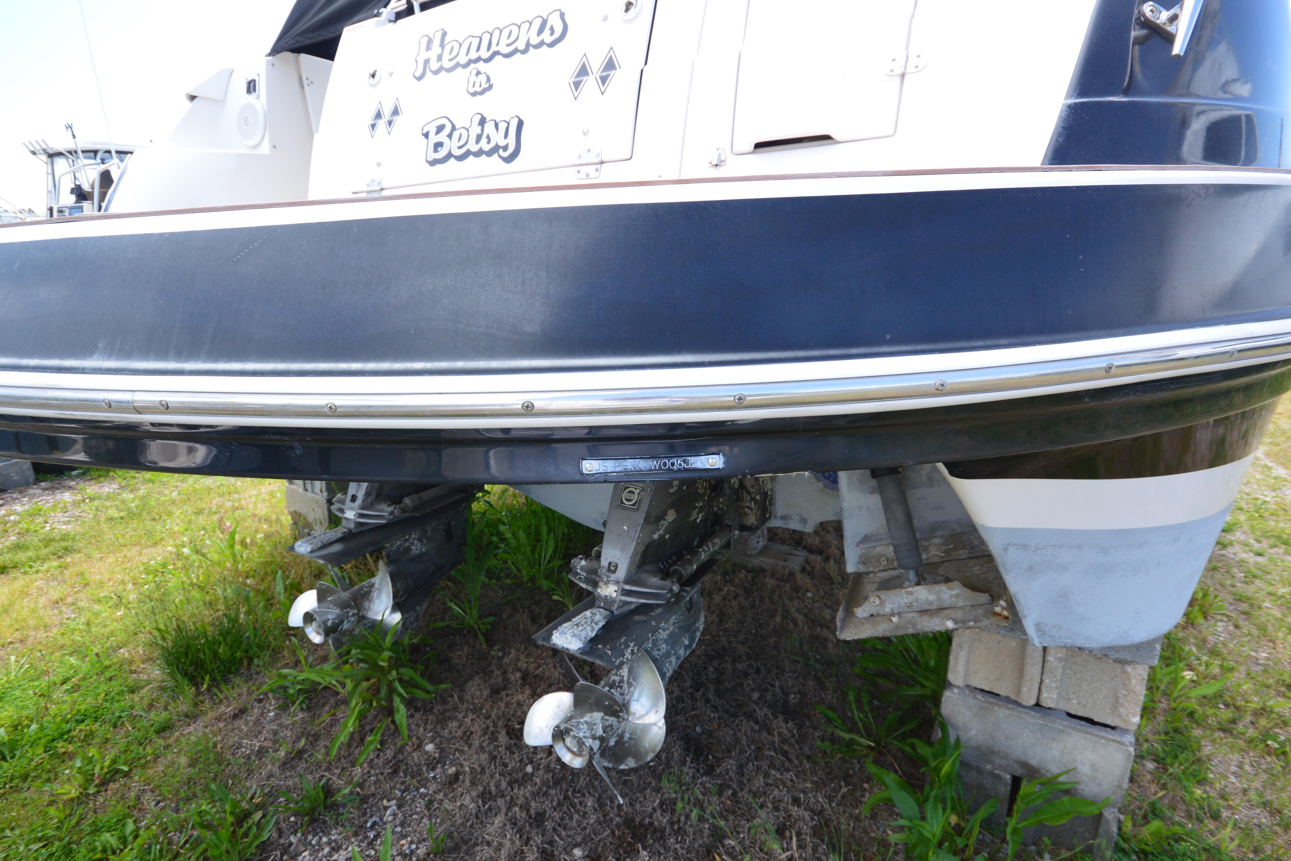 2013 Four Winns V375 boat stern view with dual propellers on land.