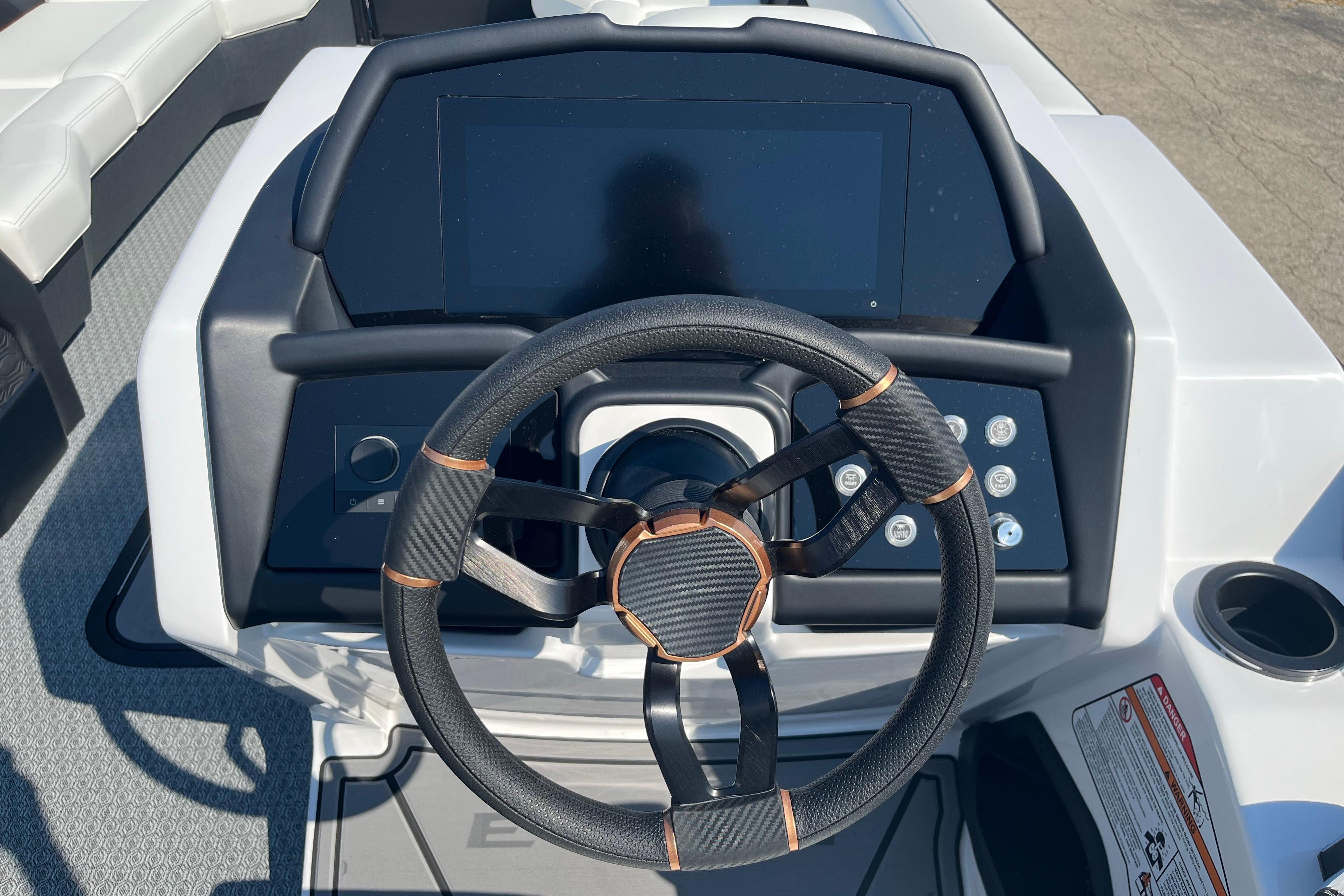 Steering wheel and dashboard of 2026 Evotti 725CS boat, featuring modern controls and touchscreen.