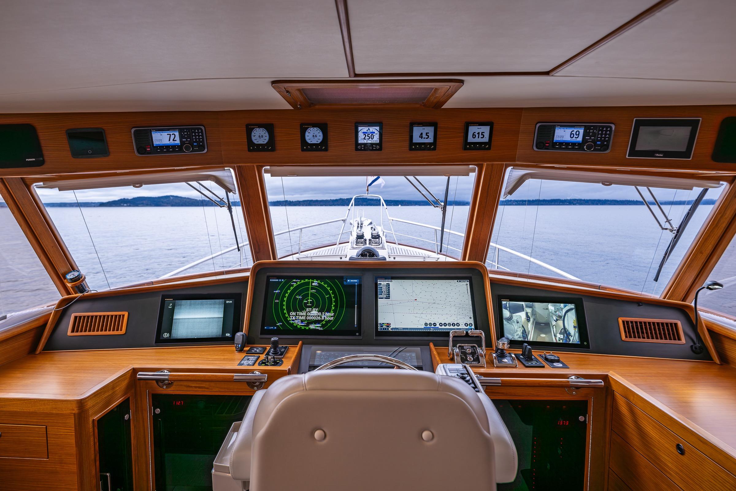Pilothouse of 2026 Fleming 55 yacht with advanced navigation systems and panoramic sea view.