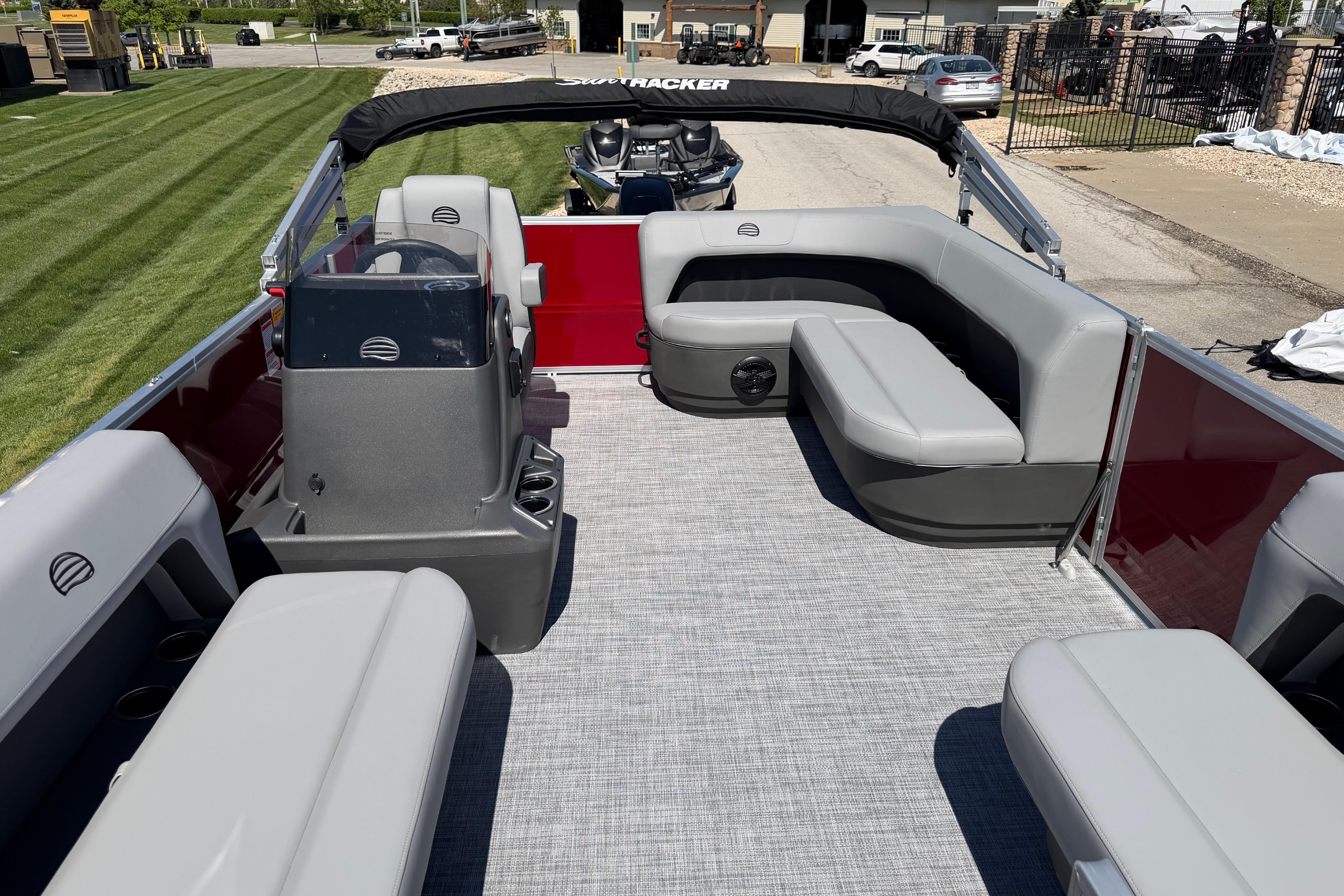 2026 Sun Tracker Party Barge 16 DLX interior with gray seating and helm.