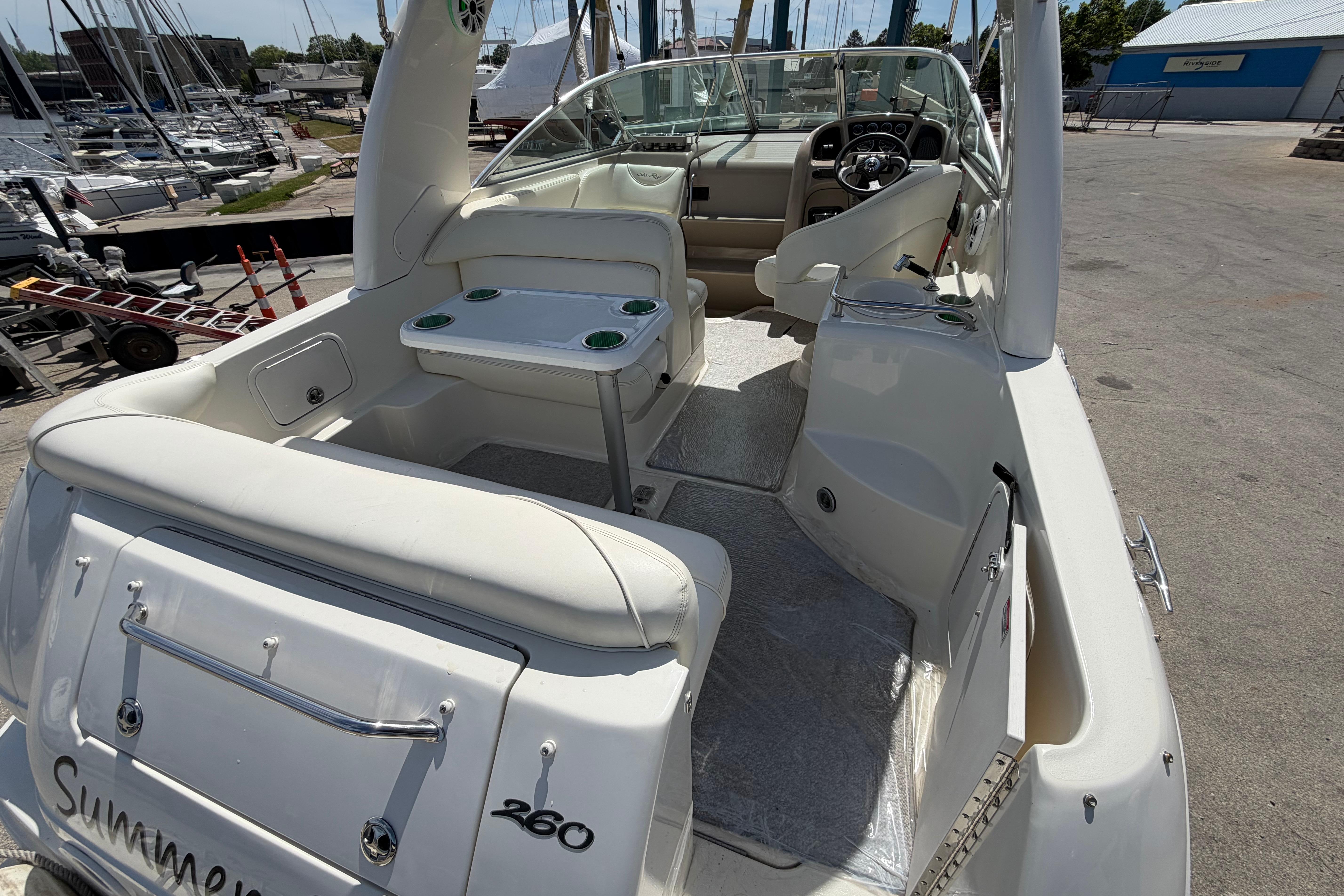 2004 Sea Ray Sundancer 260 boat interior with seating and helm, docked at marina.