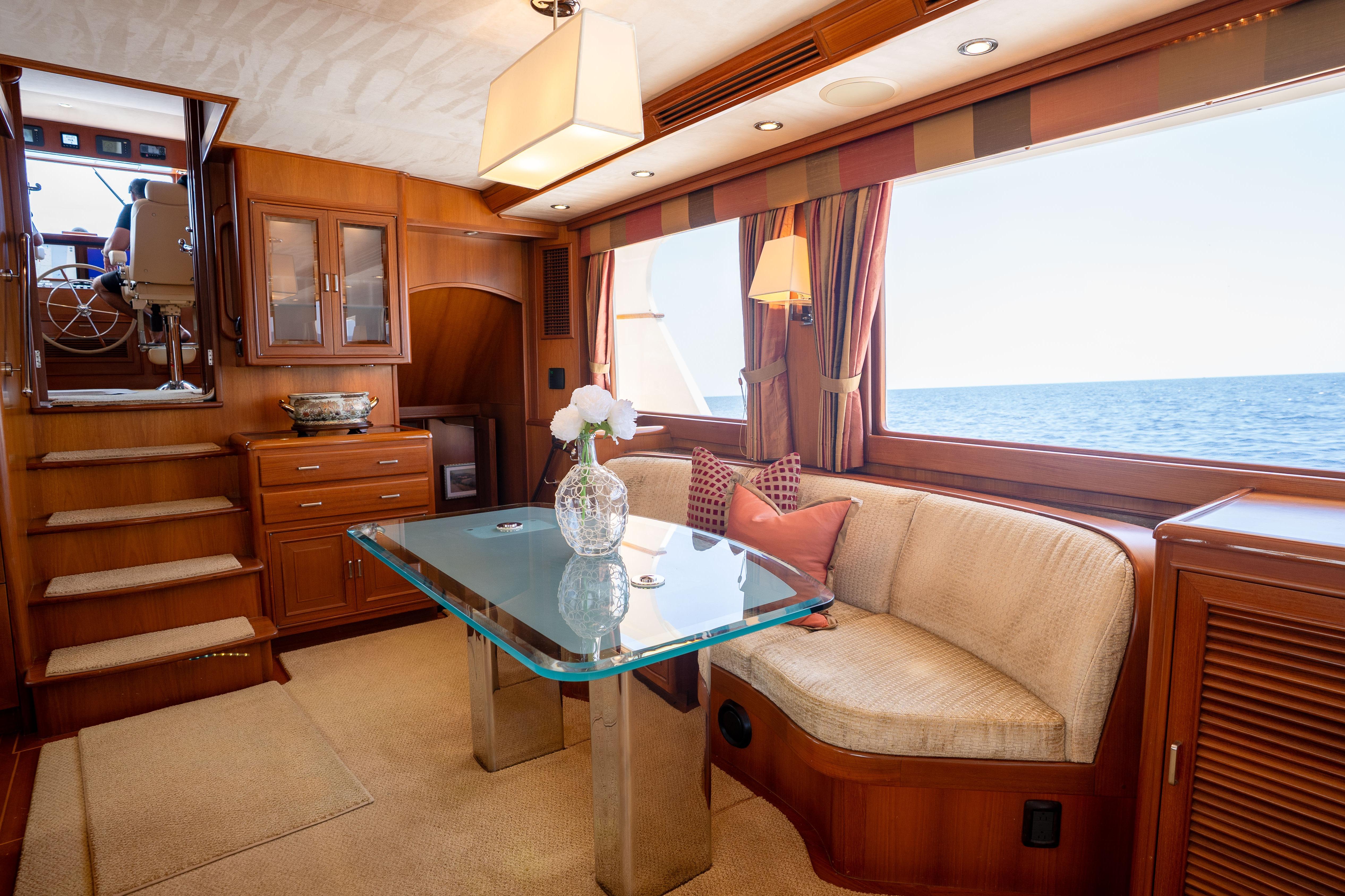 Luxurious interior of a 2006 Fleming 75 yacht with elegant dining area and ocean view.