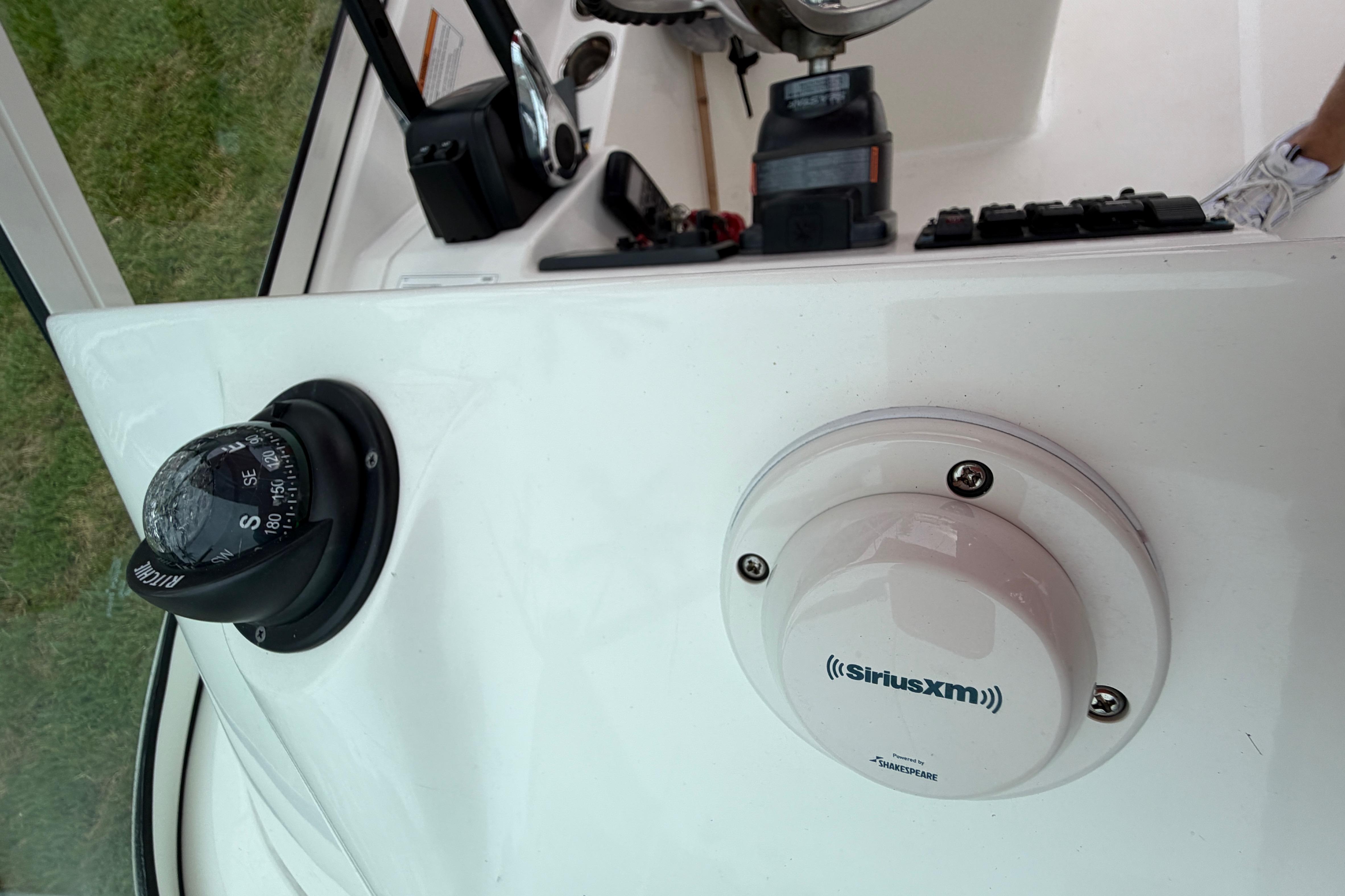 Control panel of a 2019 World Cat 230 DC boat with compass and SiriusXM antenna.