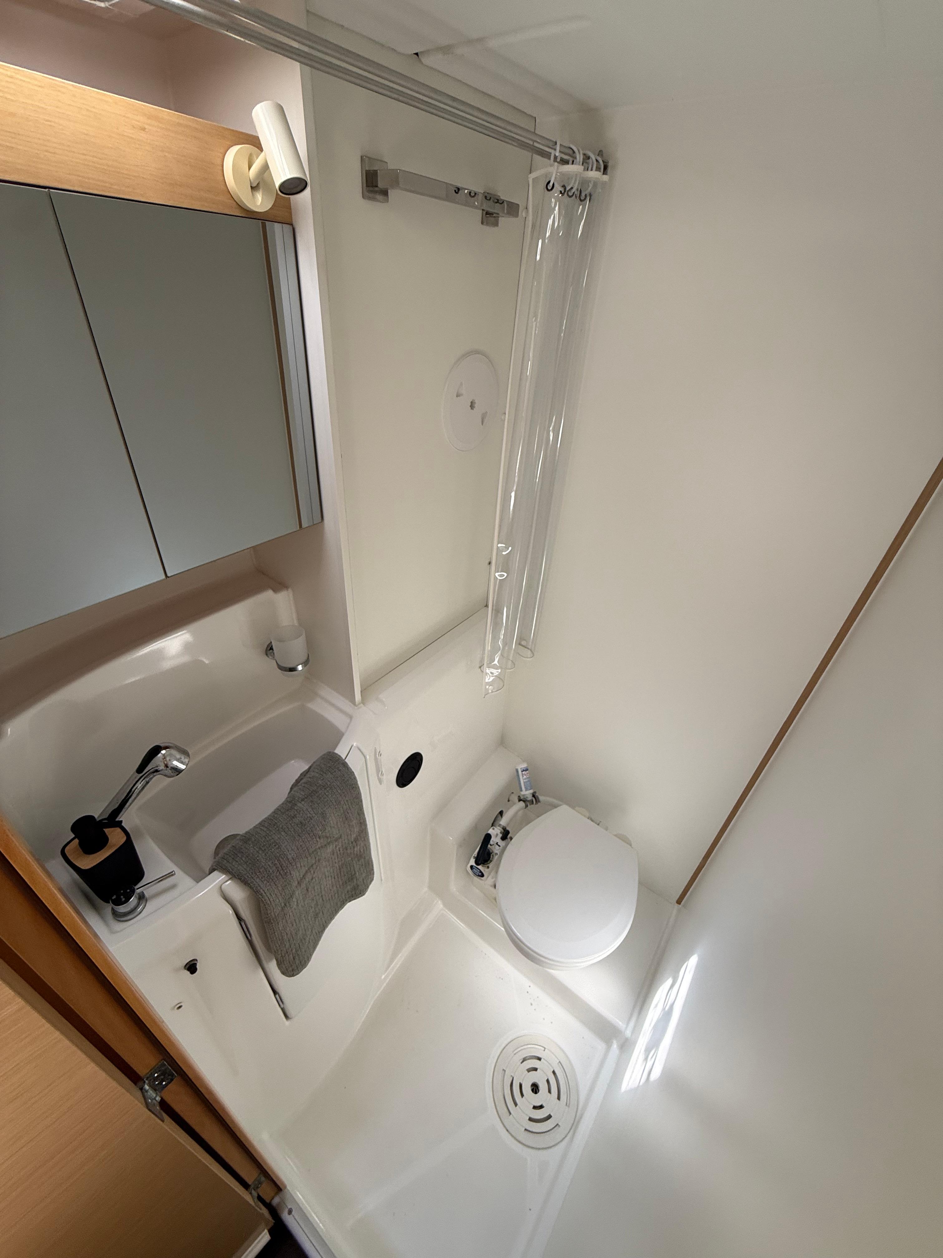 Compact bathroom in 2017 Lagoon 400 S2 yacht with shower, sink, and toilet.