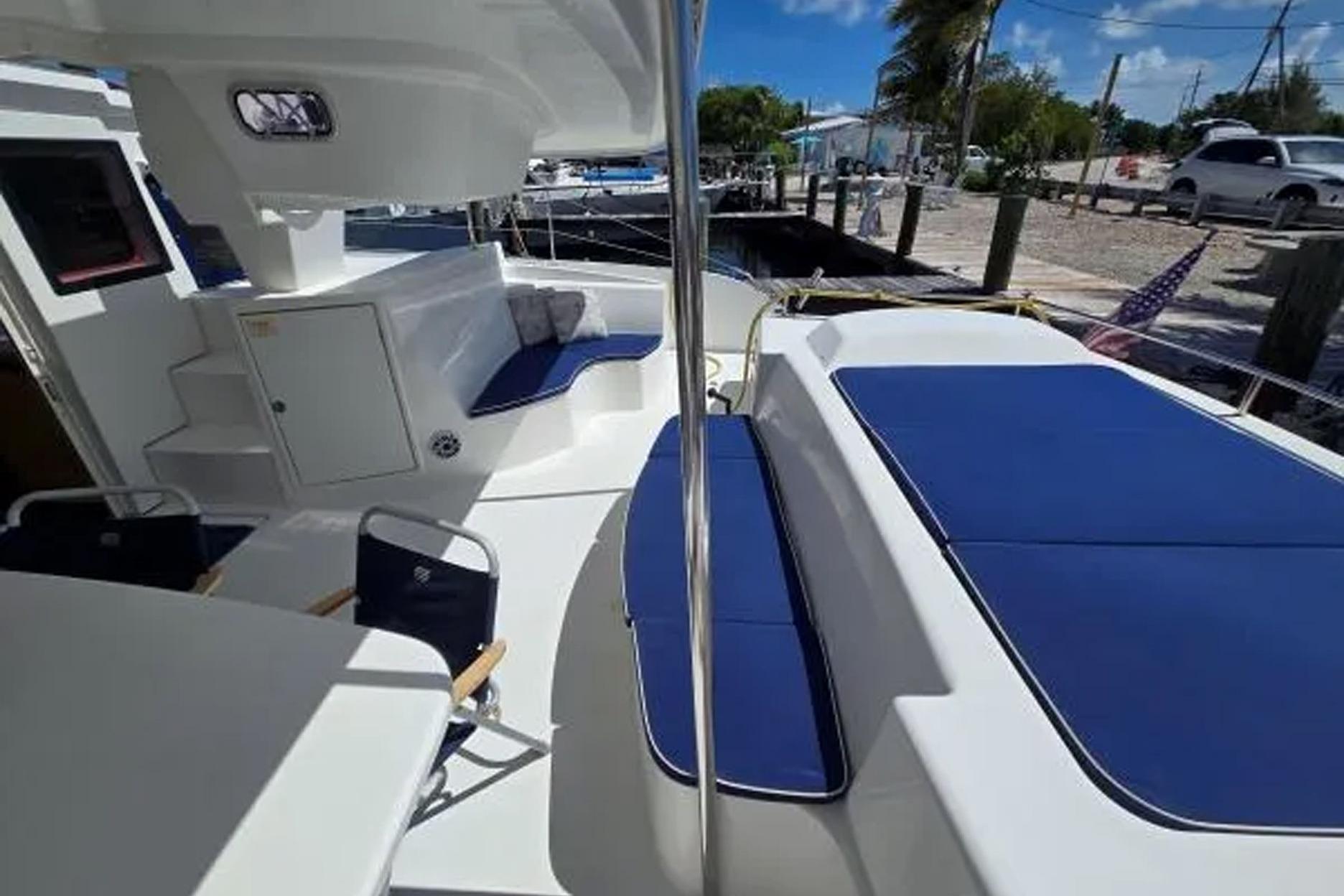 2008 Fountaine Pajot Salina 48 catamaran with spacious deck and blue seating cushions.