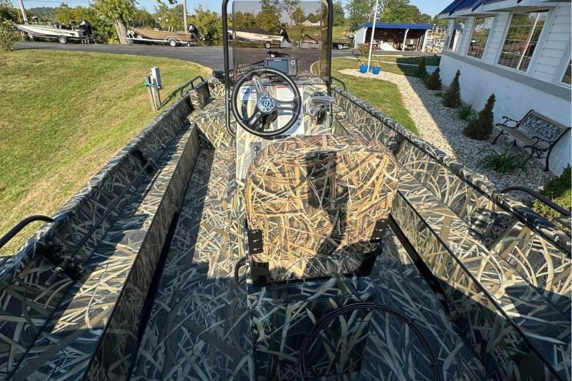 2026 Smoker Craft Sportsman 1866 boat with camouflage interior, parked outdoors.