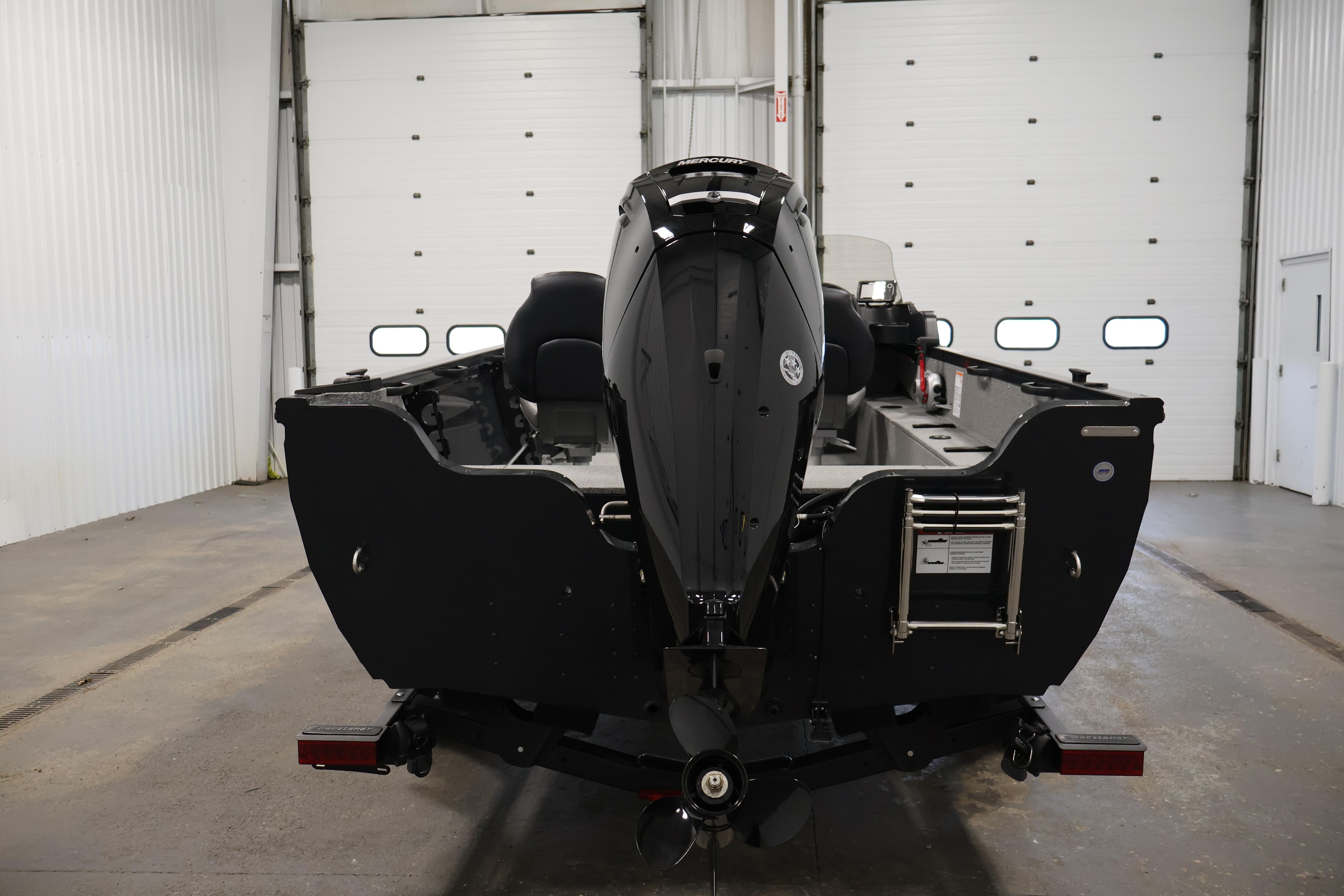 2026 Crestliner 1850 Kodiak SC boat in a garage, rear view with outboard motor.