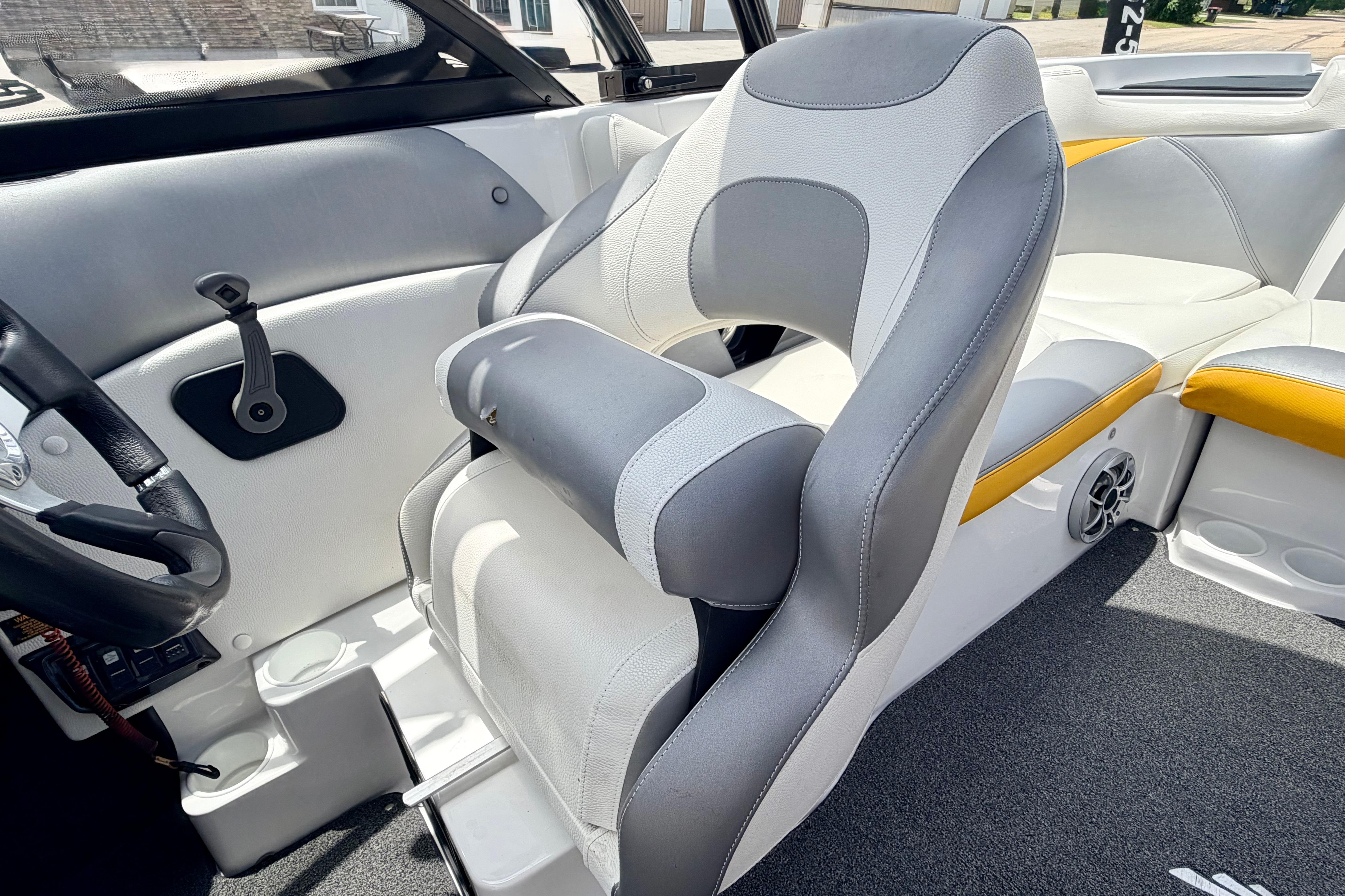 2014 Tigé R20 boat interior with gray and white seating, steering wheel, and speaker.
