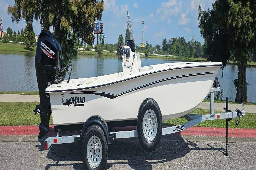 2026 Mako Pro Skiff 15 CC boat on trailer by a scenic lake.
