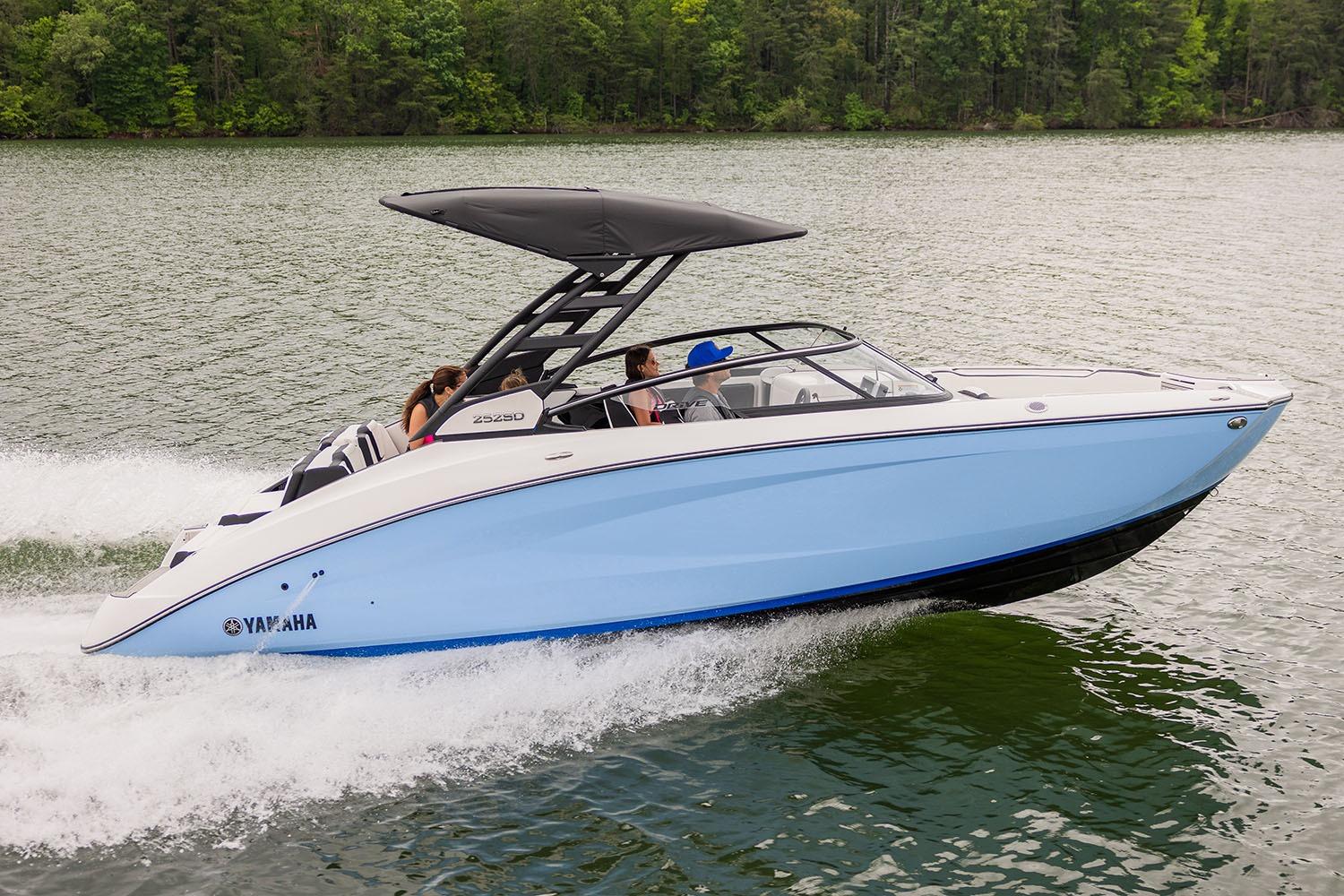 Manufacturer Provided Image: 2026 Yamaha Boats 252SE cruising on a lake with passengers, surrounded by lush greenery.