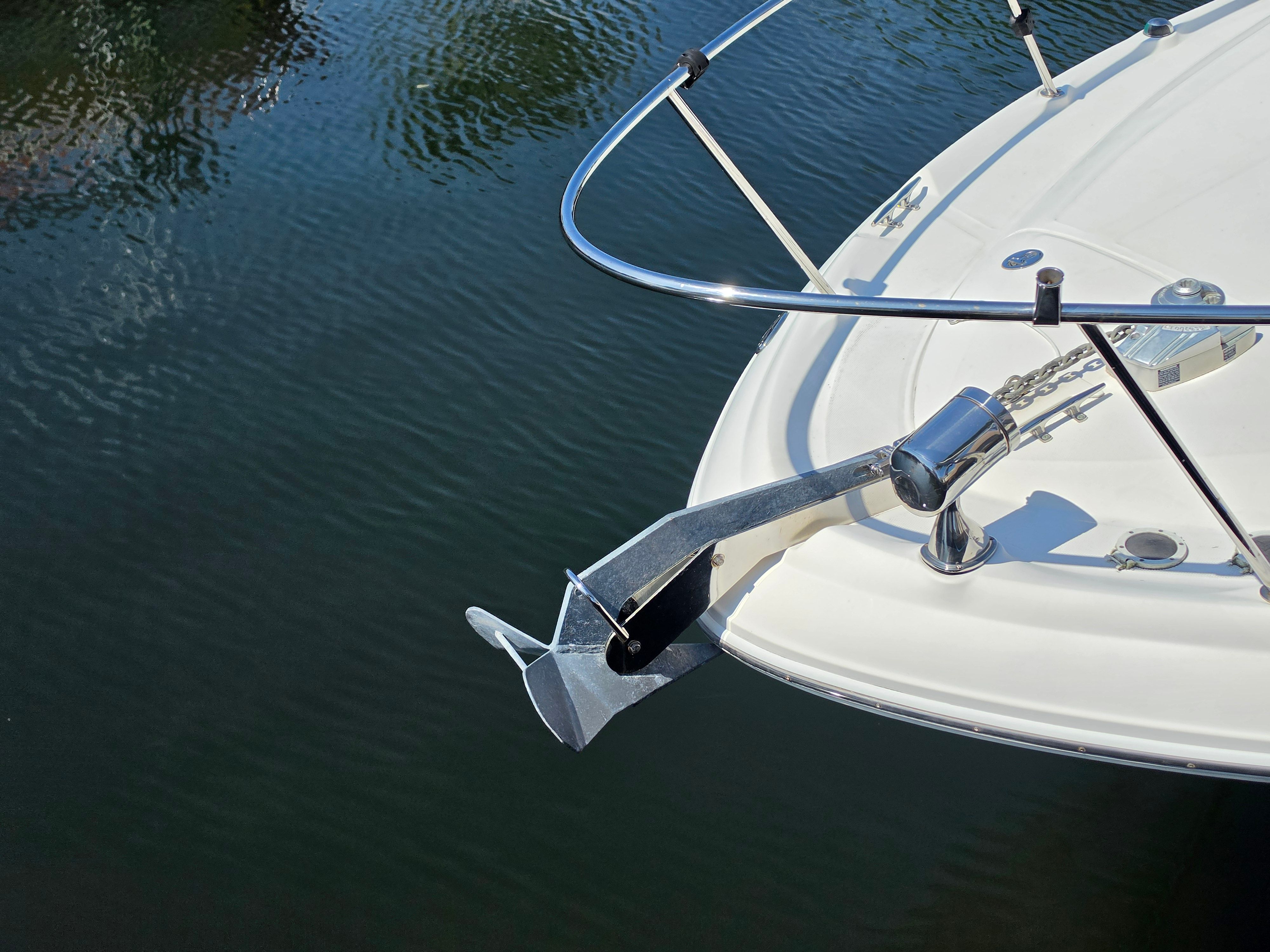 Bow of a Sea Ray 340 Sundancer with anchor over calm water.