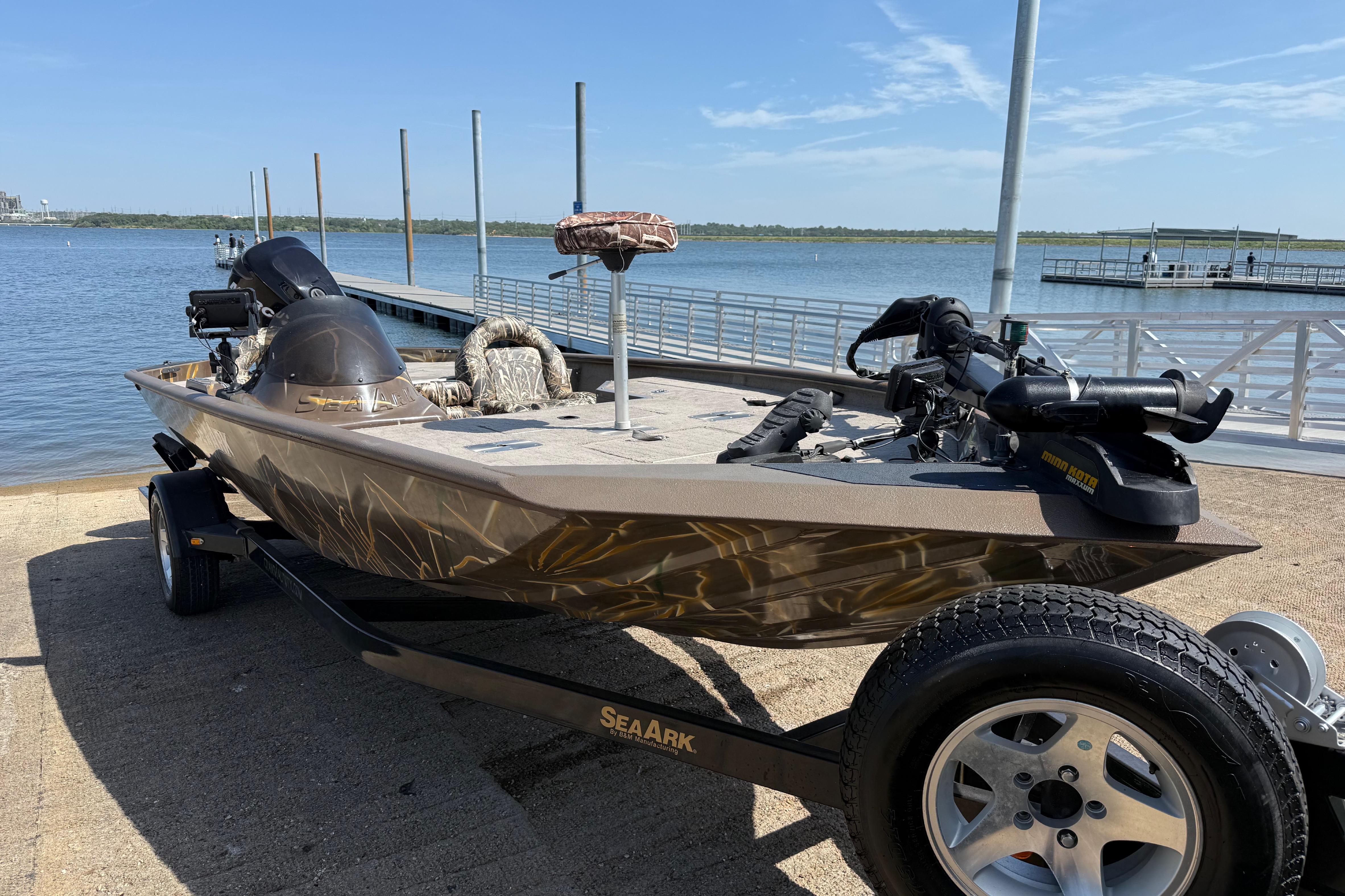 2010 SeaArk Stealth 190 boat on trailer by a lakeside dock.