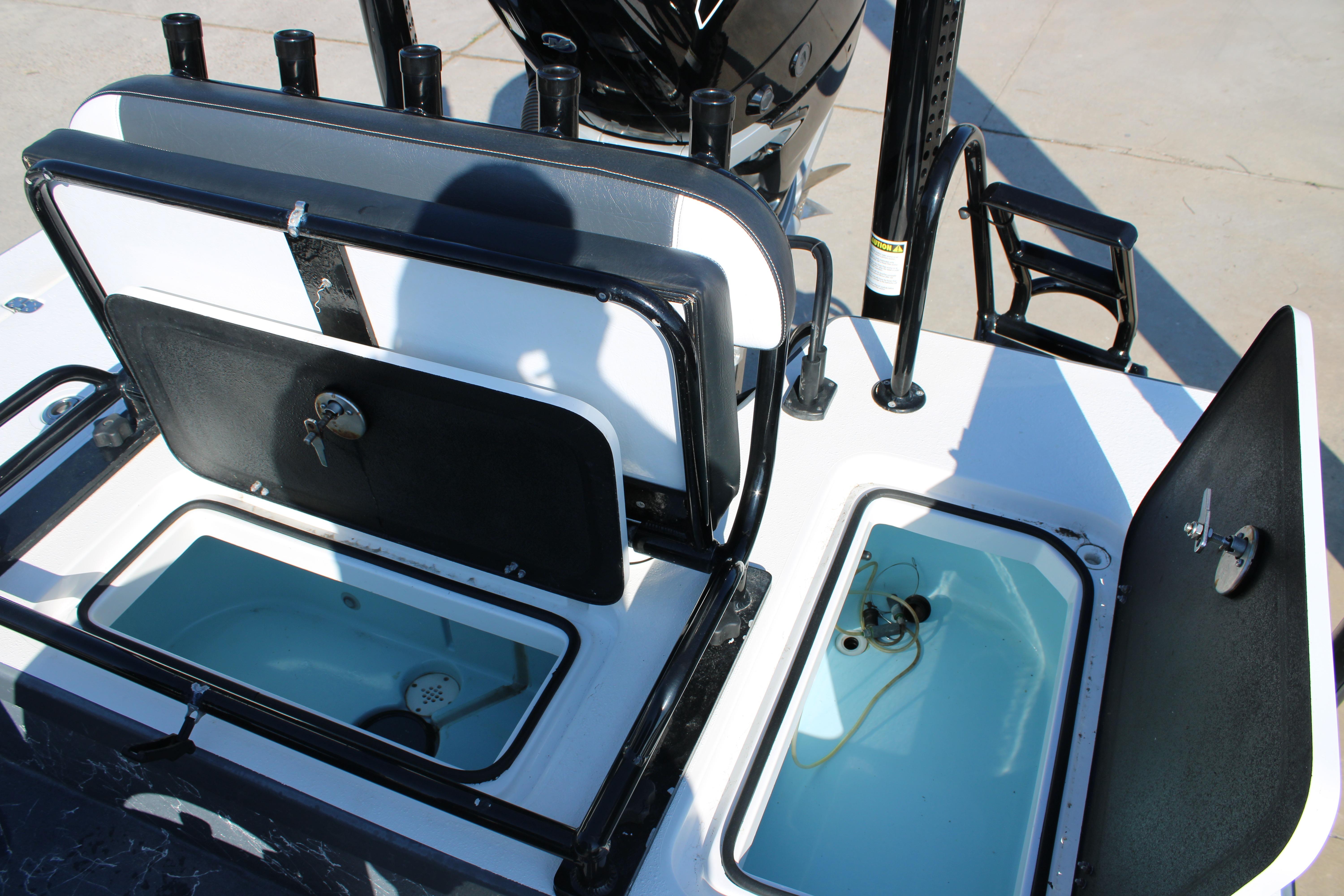 Open storage compartments on a 2023 Mamba 24VX boat, showcasing interior features.