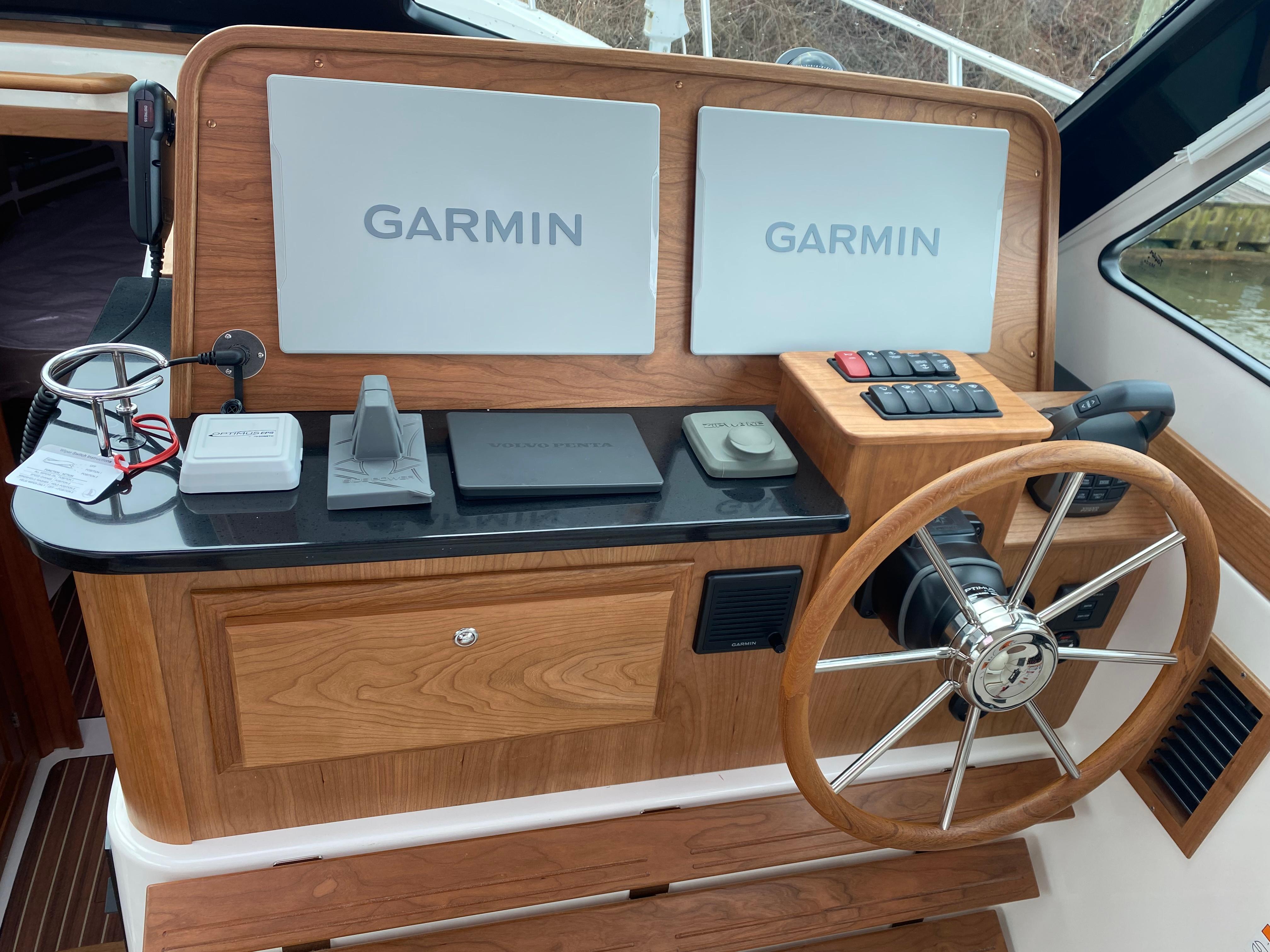 2025 Back Cove 37 Hardtop Express helm with dual Garmin displays and wooden steering wheel.