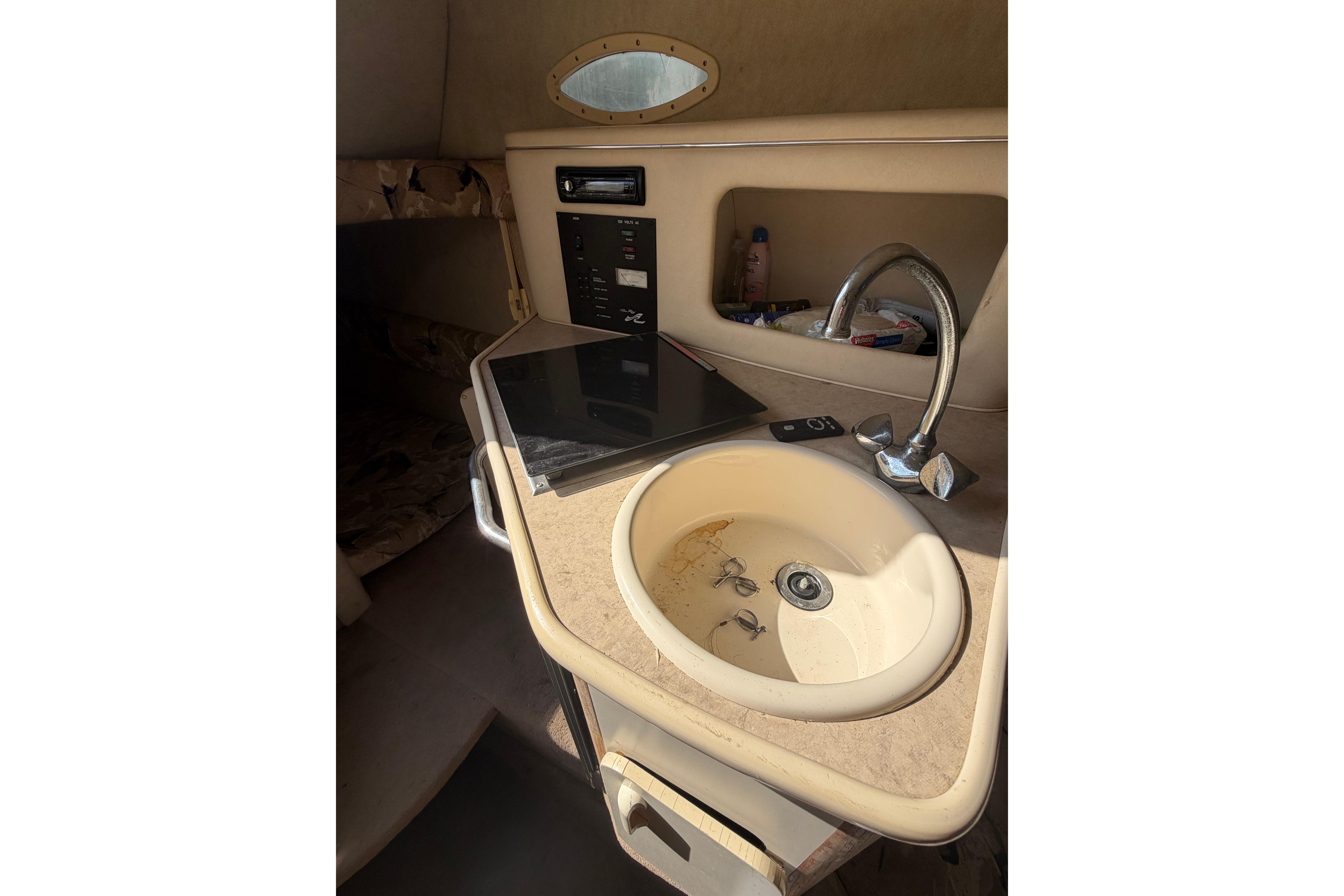 1999 Sea Ray 240 Sundancer cabin interior with sink and control panel.