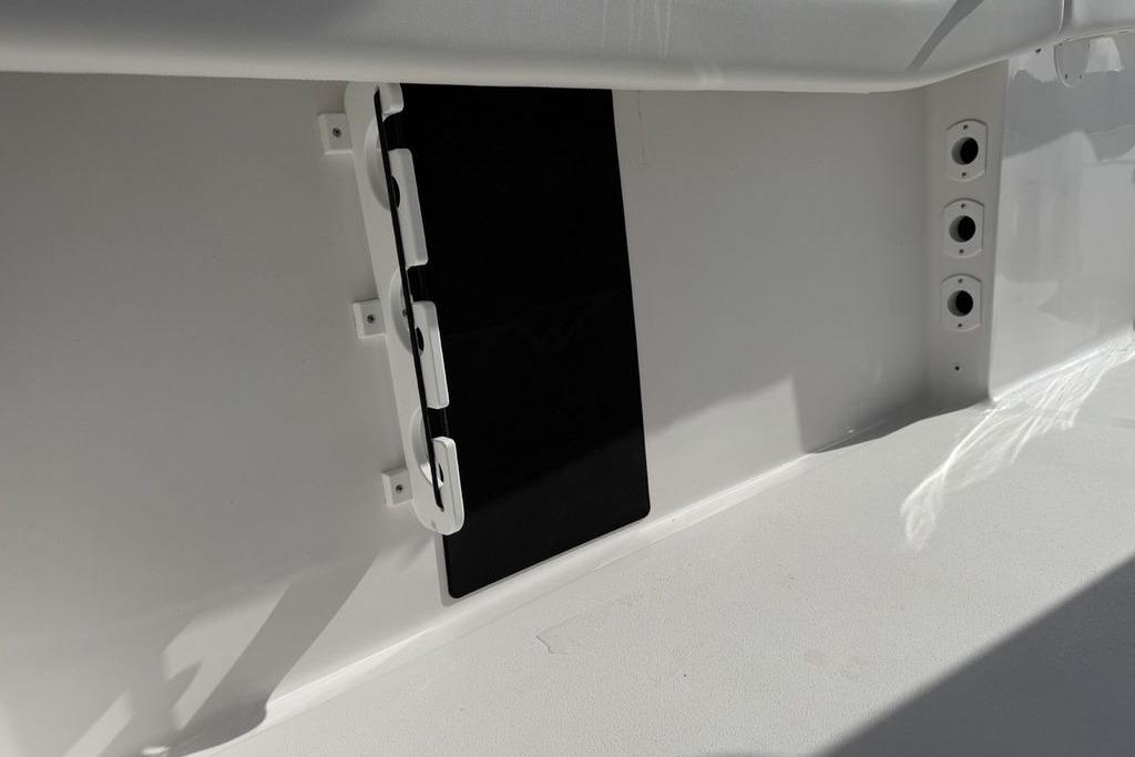 2026 Tidewater 232 LXF boat interior detail with storage compartment and rod holders.
