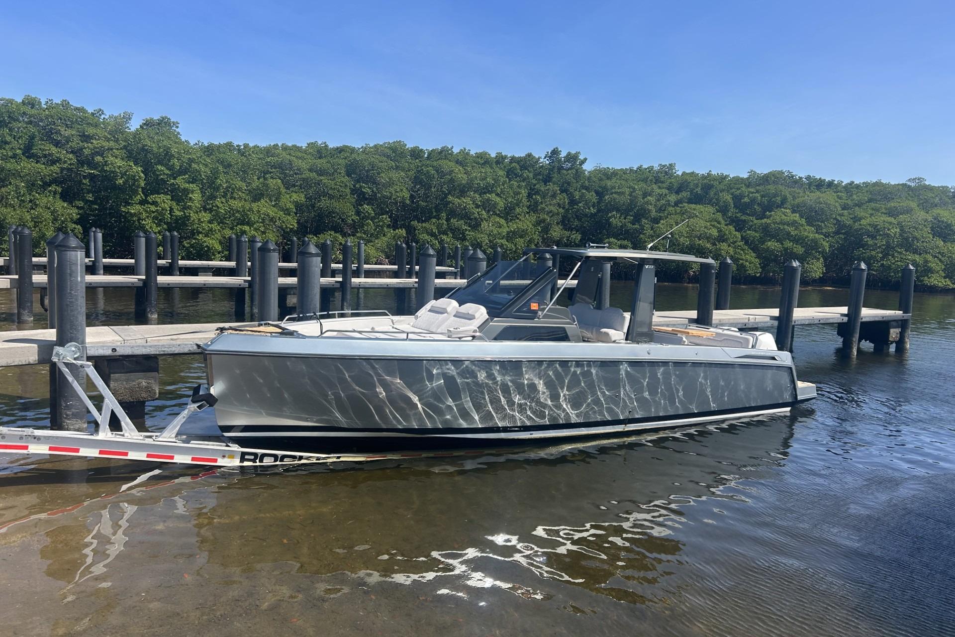 2023 Schaefer V33 boat docked at a marina, surrounded by lush greenery.