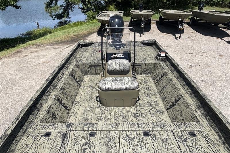 2026 Tracker Grizzly 2072 CC boat with camouflage design, parked near a lake.