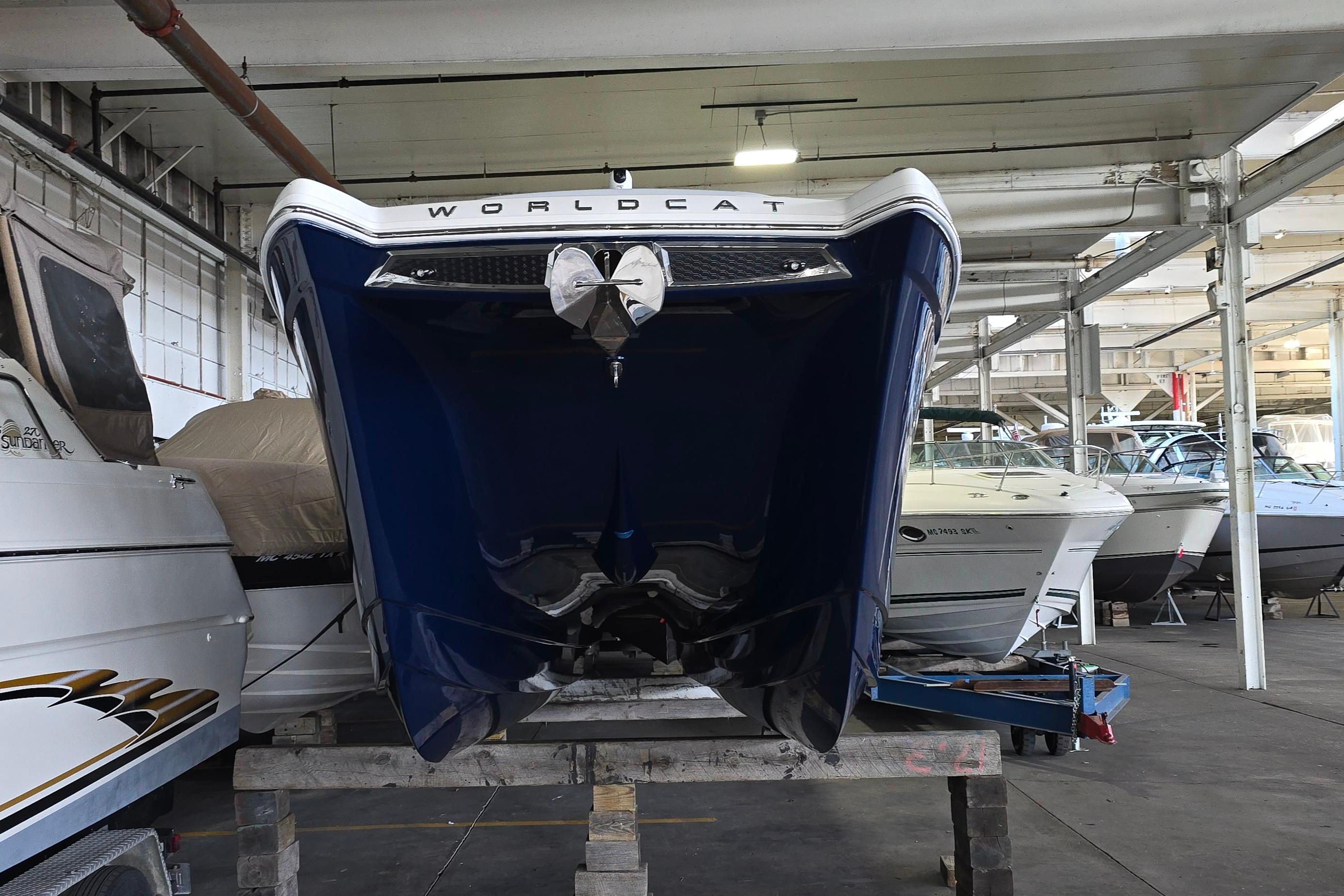 2024 WorldCat 280 CC-X boat in storage, front view, blue hull, indoor marina.