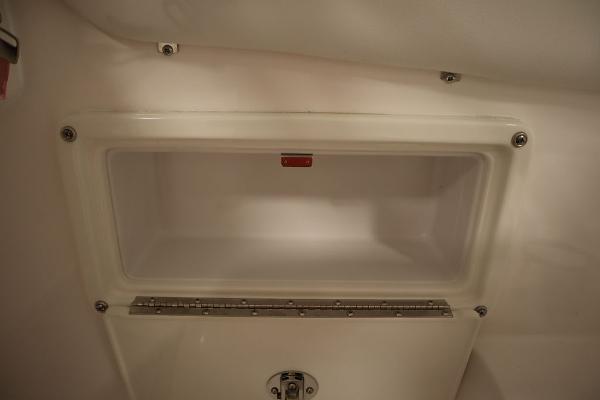 2025 Sea Fox 228 Traveler storage compartment, white interior, secure latch.