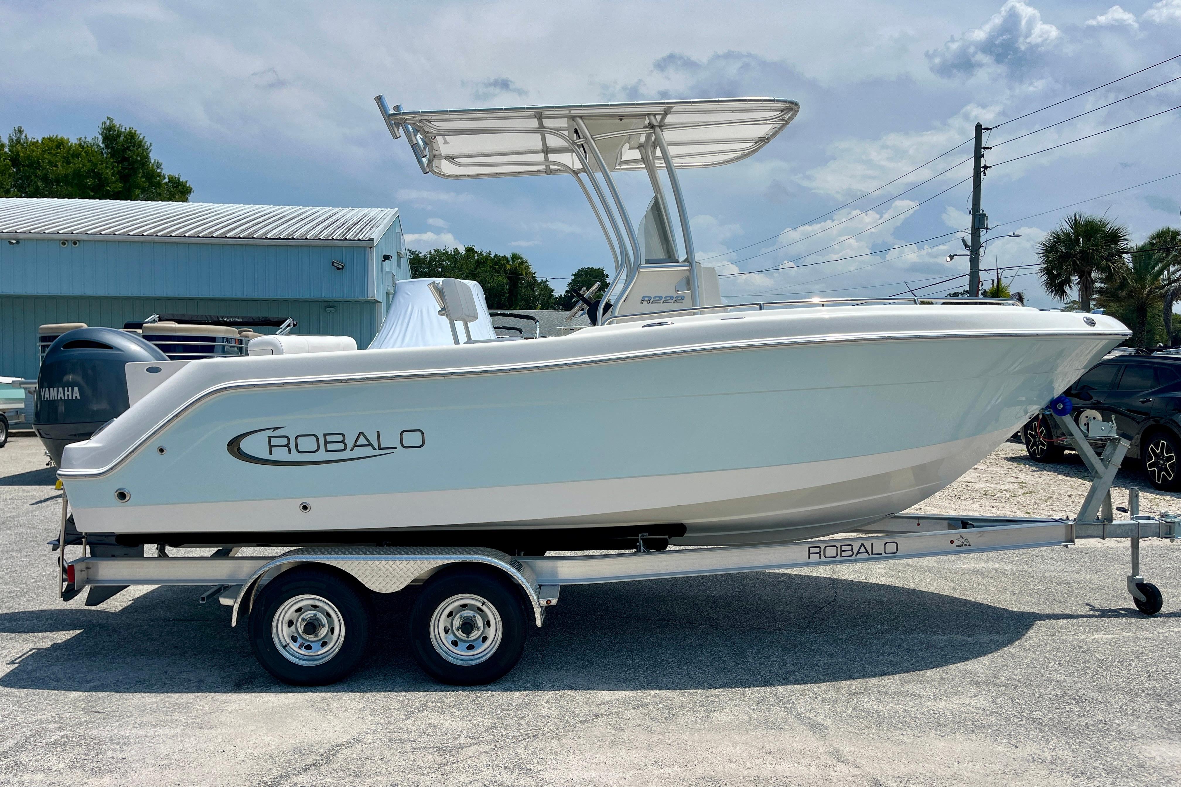 2016 Robalo R222 Center Console boat on trailer, parked outdoors under a cloudy sky.