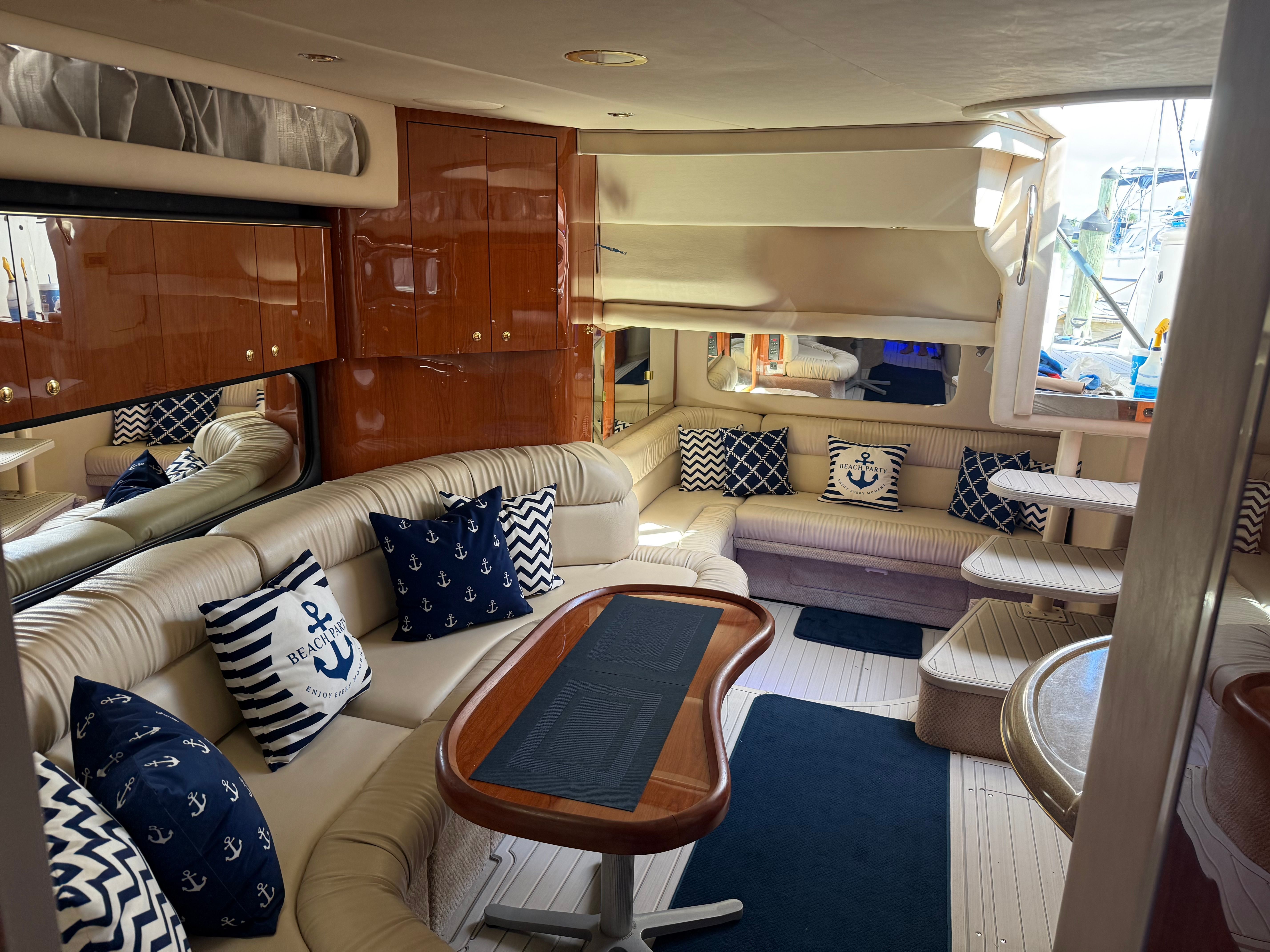 Interior of a luxury yacht with cream leather sofas and nautical-themed cushions.