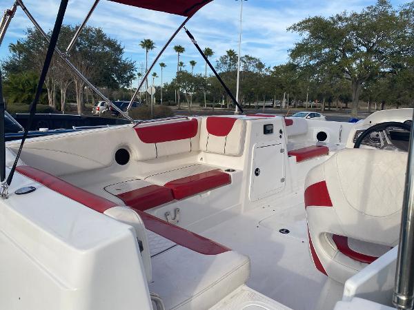 2022 Tahoe 2150 boat interior with red and white seating, parked outdoors.