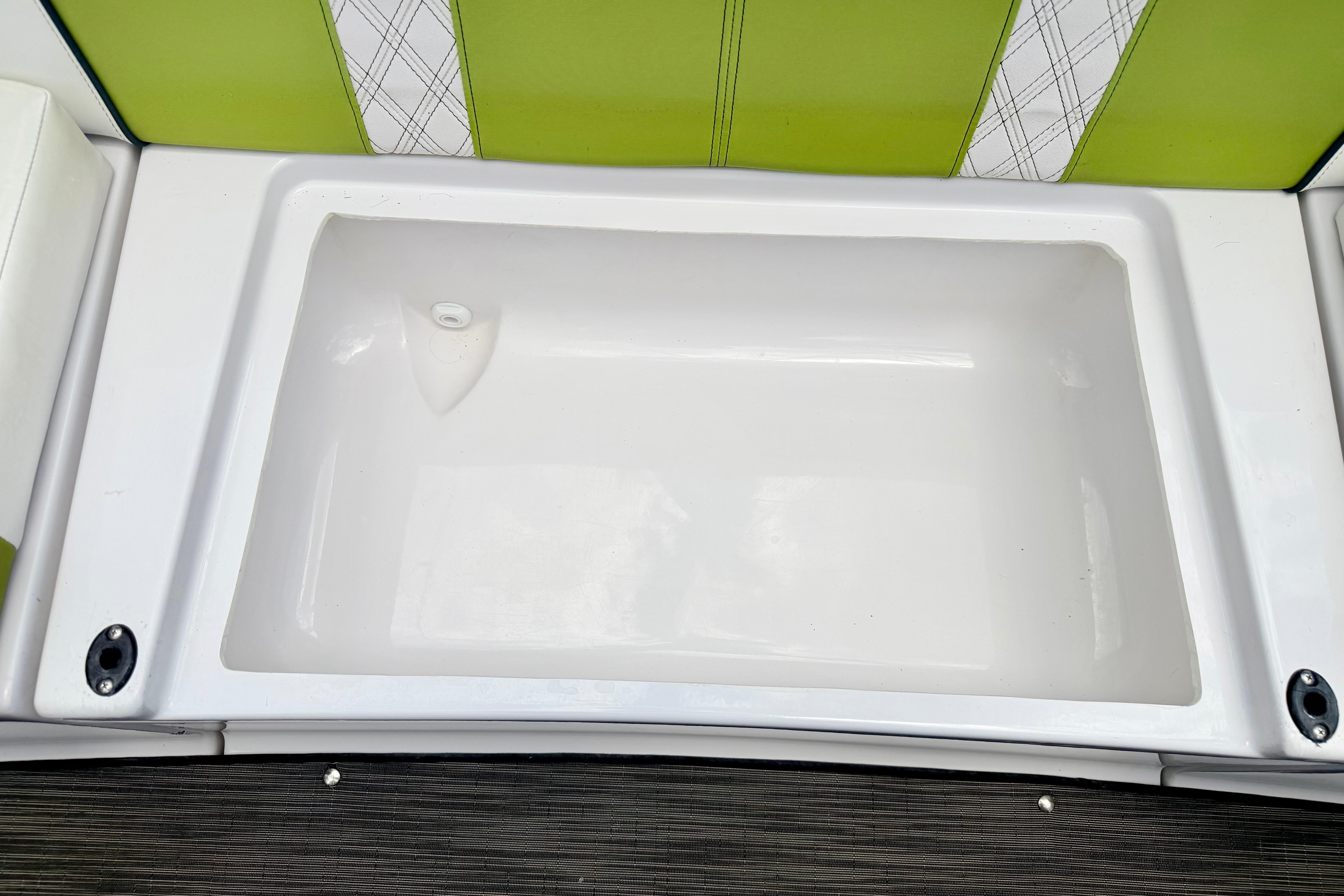 2018 Glastron GT 185 boat interior with green and white seating and storage compartment.