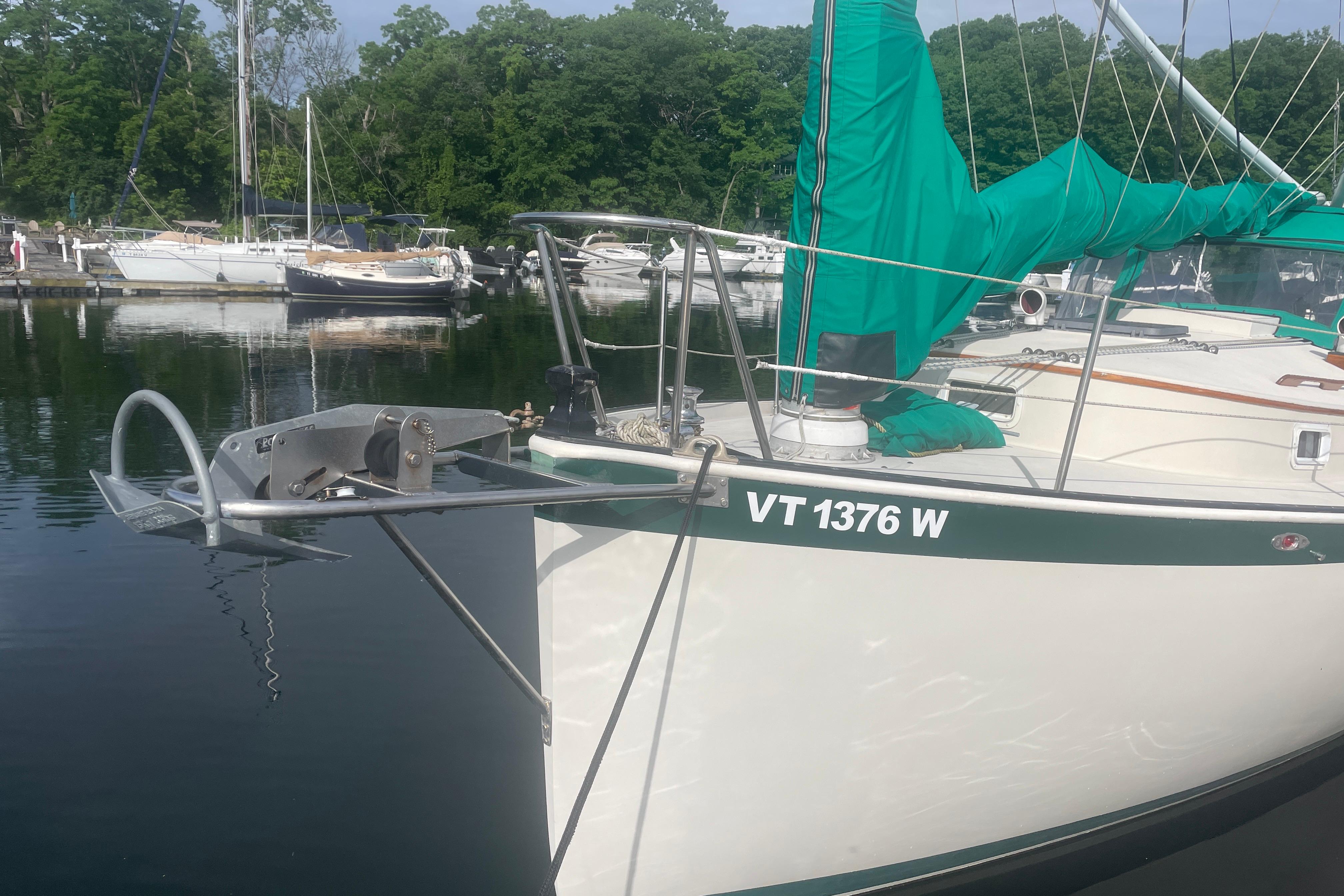 1981 Nonsuch 30 Classic sailboat docked, featuring green sail cover and visible registration number.