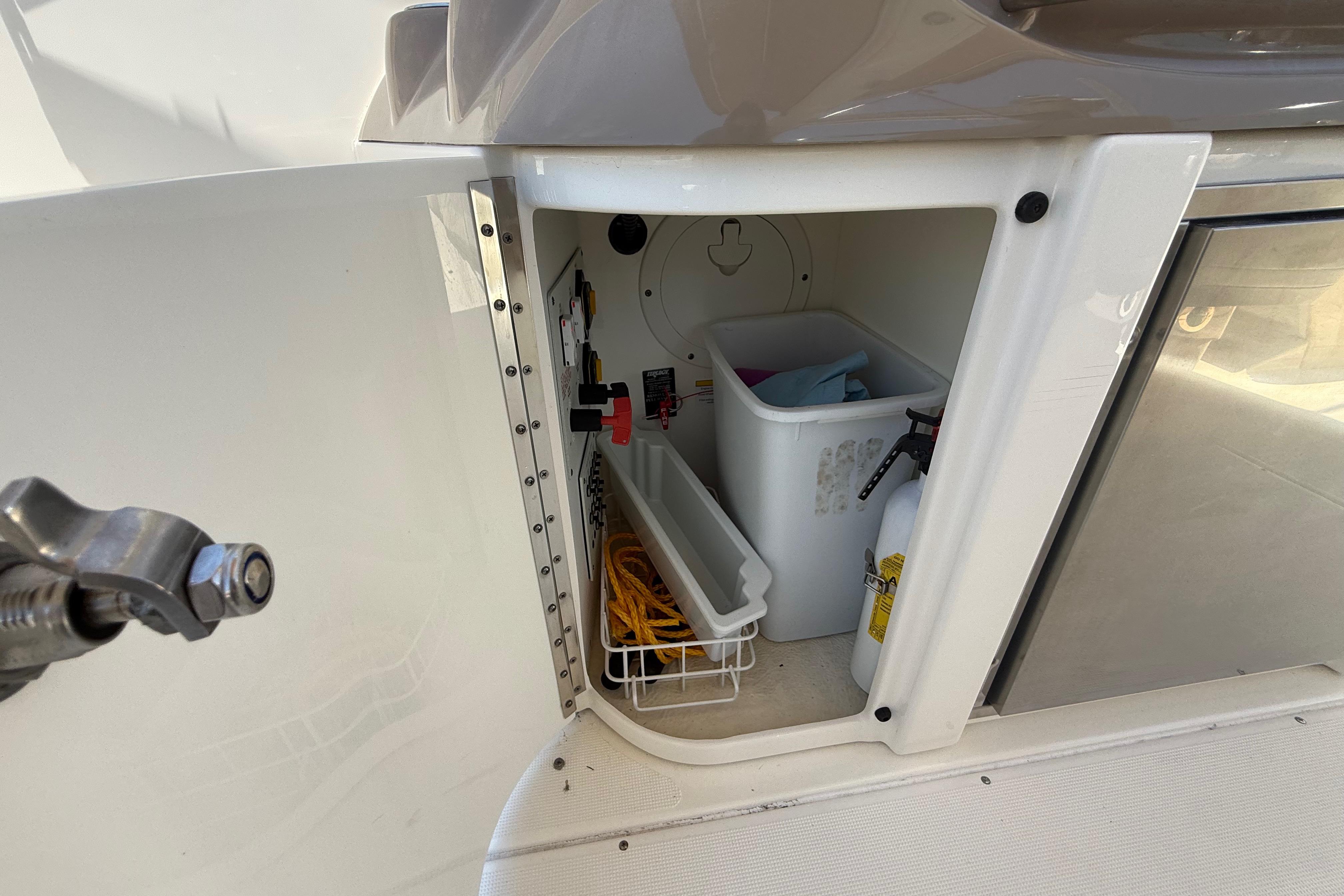 Storage compartment on a 2015 Formula 310 Bowrider, featuring safety equipment and accessories.