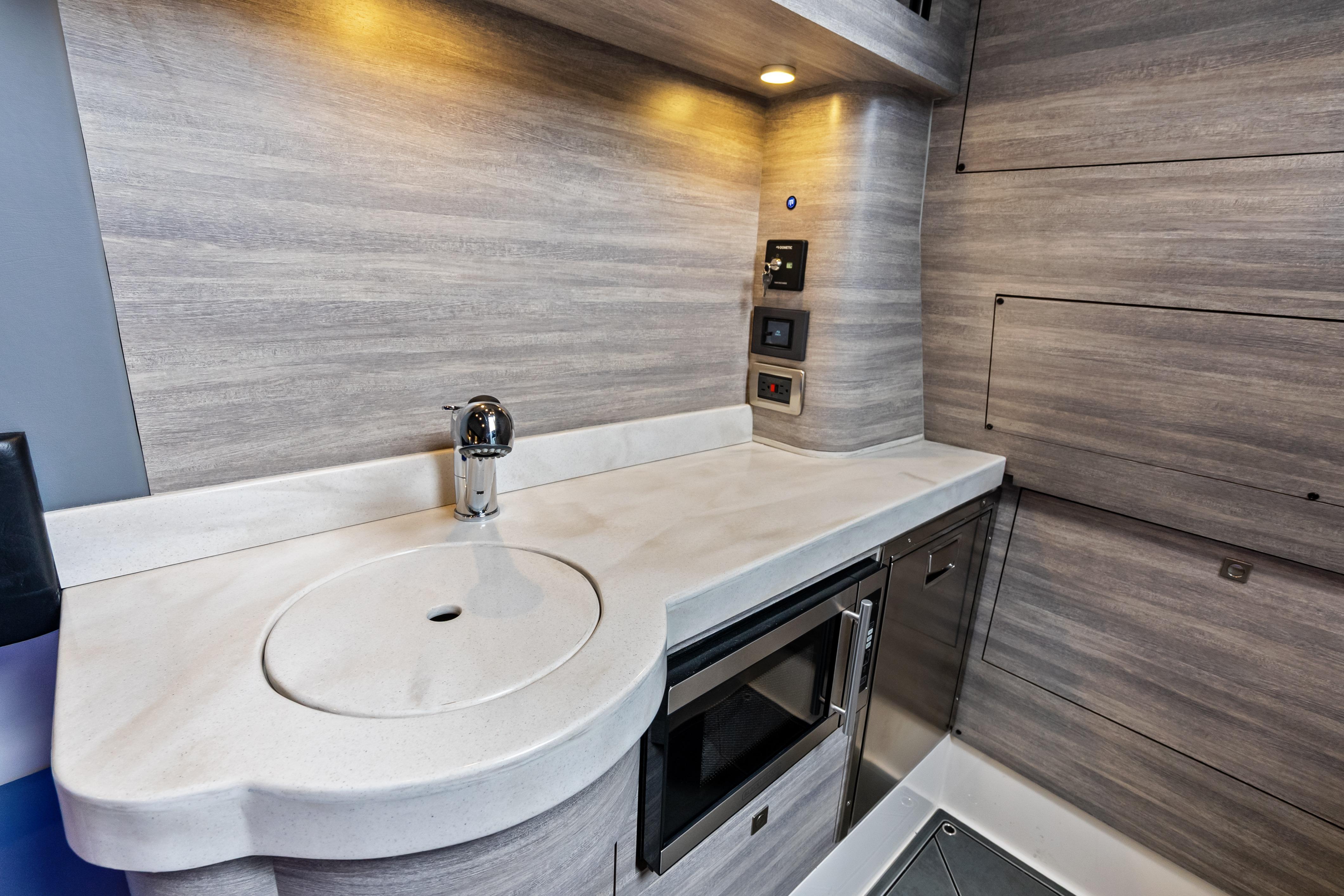 Modern kitchenette in 2027 Mystic Powerboats M4200, featuring sleek cabinetry and stainless steel appliances.