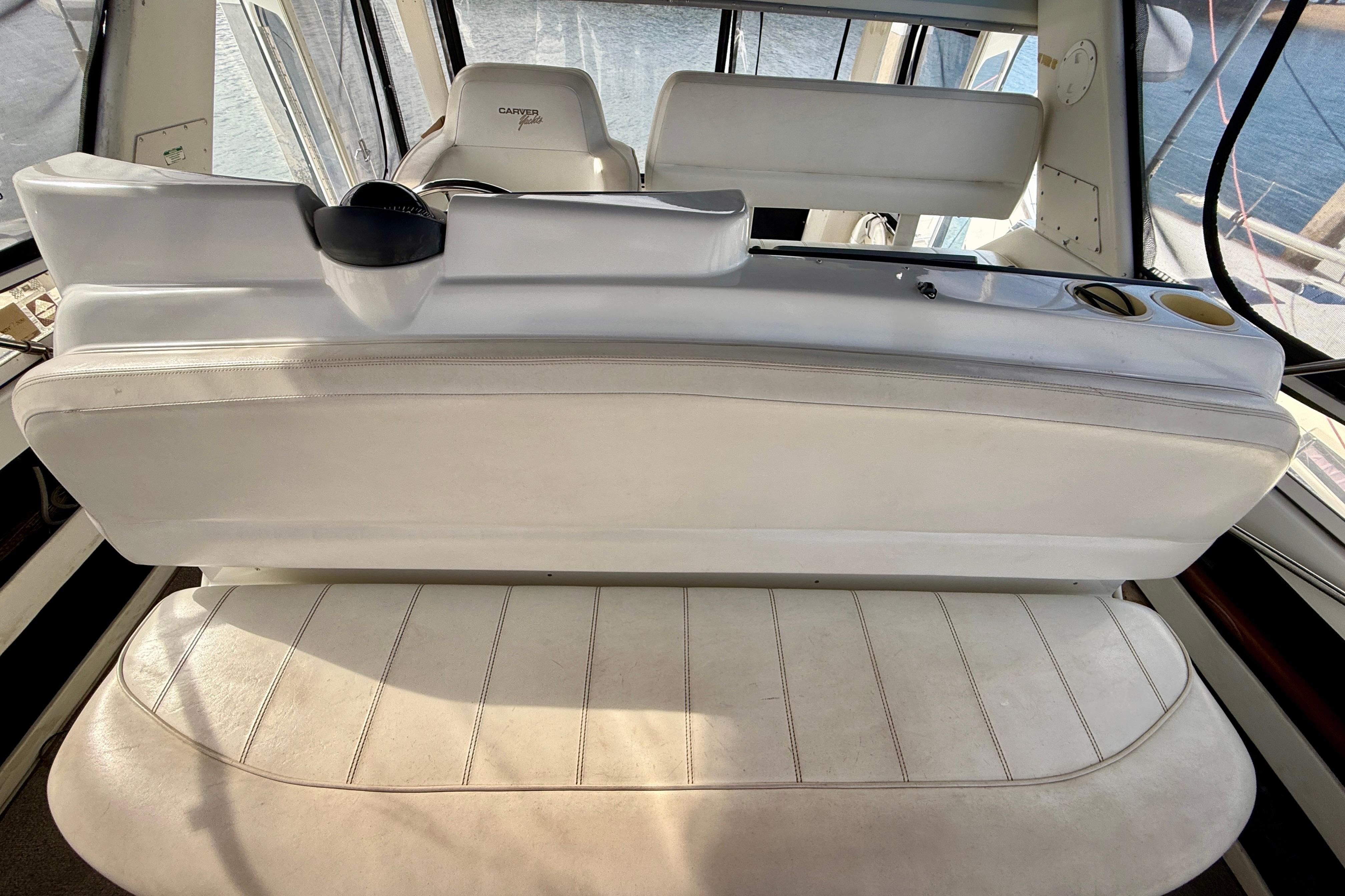 1997 Carver 355 Aft Cabin Motor Yacht interior with white seating and helm view.