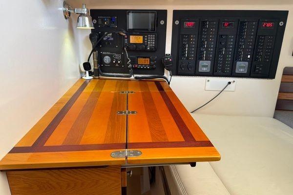Navigation station with control panels and wooden desk on a 2011 Reliance 44 yacht.