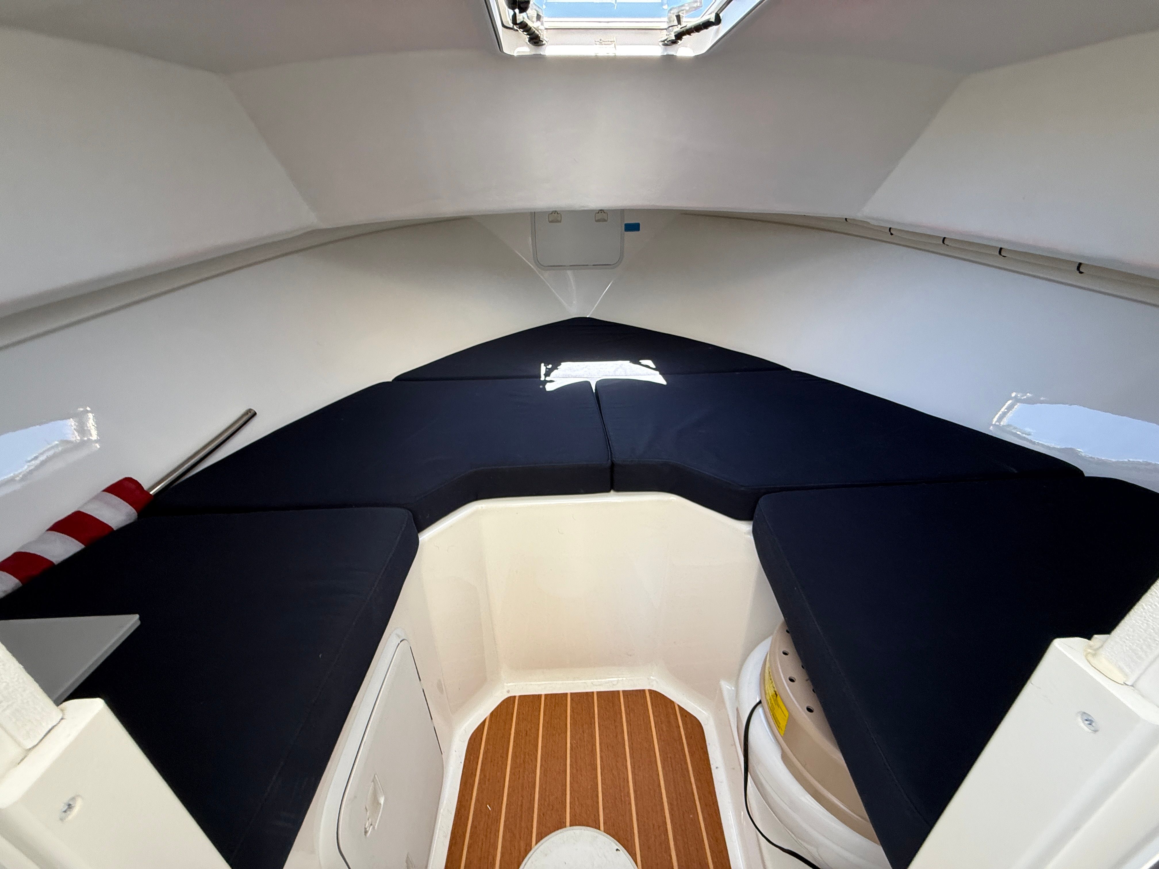 Interior of a Steiger Craft 255 Chesapeake with blue cushions and wooden flooring.