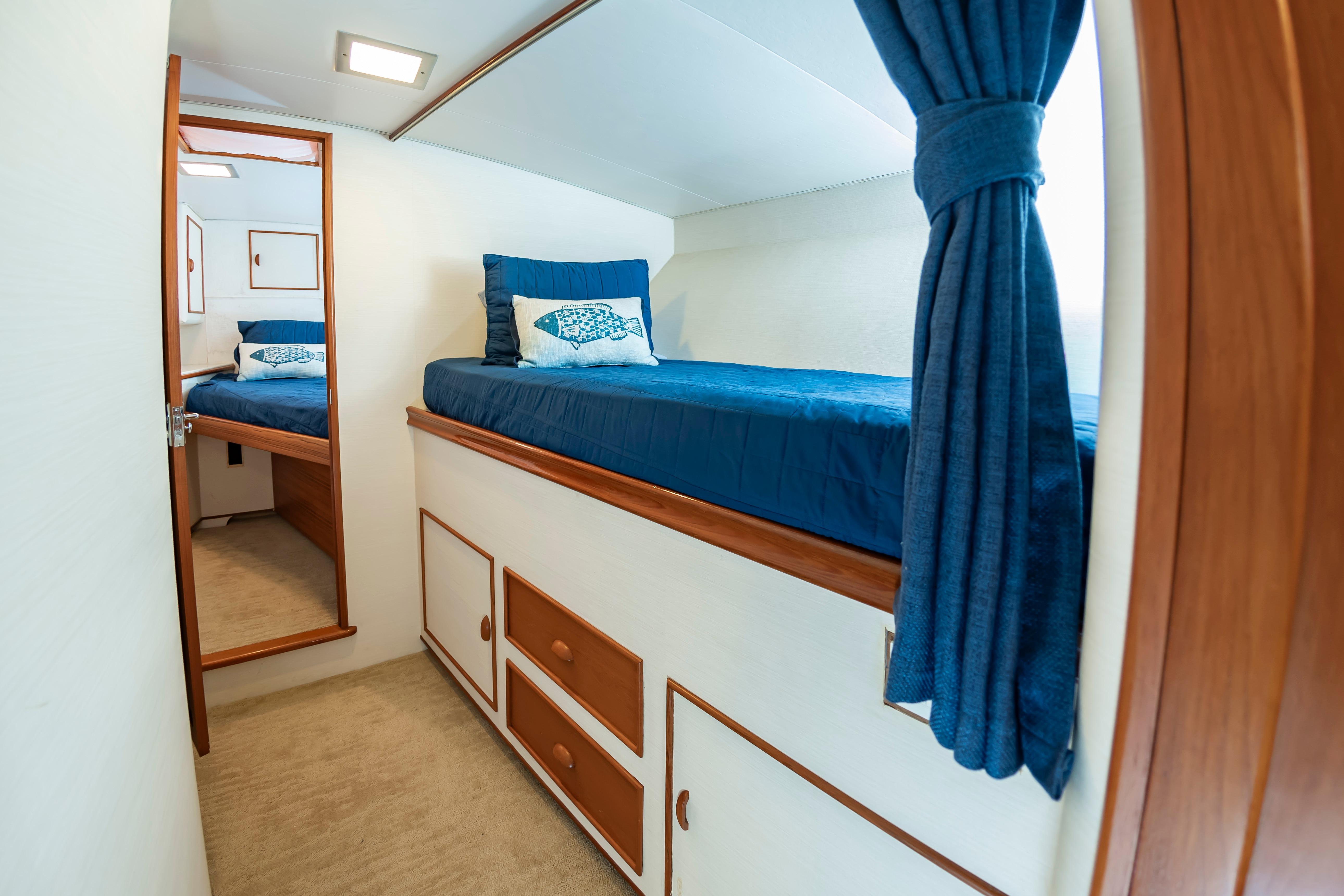 Interior cabin of 1993 Custom Carolina Scarborough 56 Convertible yacht with blue bedding.