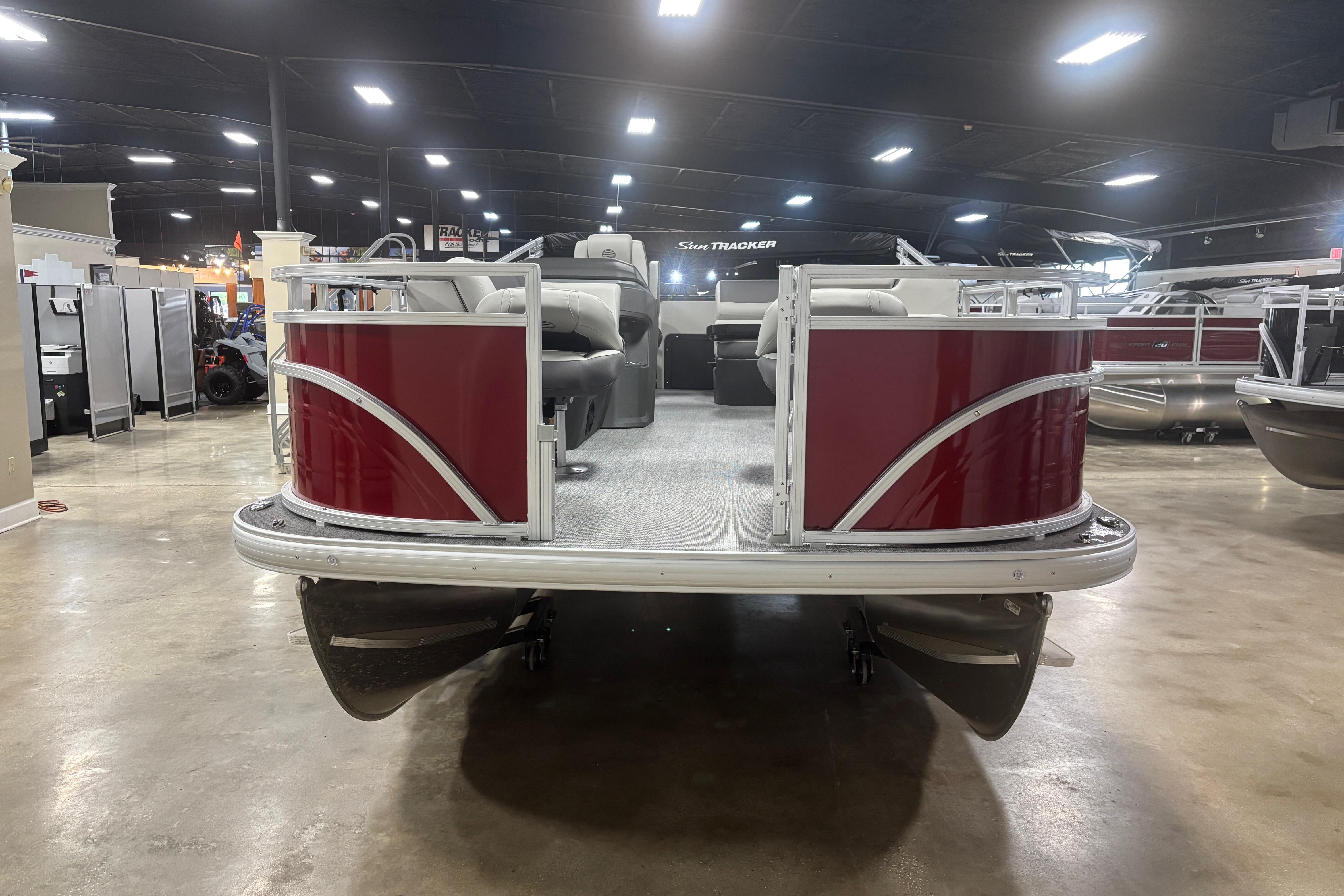 2026 Sun Tracker Fishin' Barge 22 DLX pontoon boat in showroom, front view.