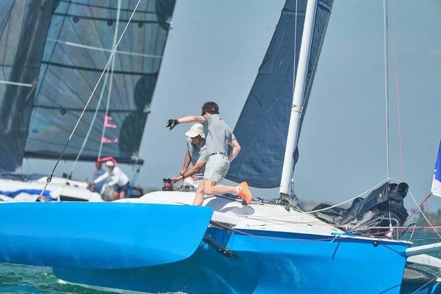 Sailors maneuvering a 1996 Farrier F-25C trimaran during a race.