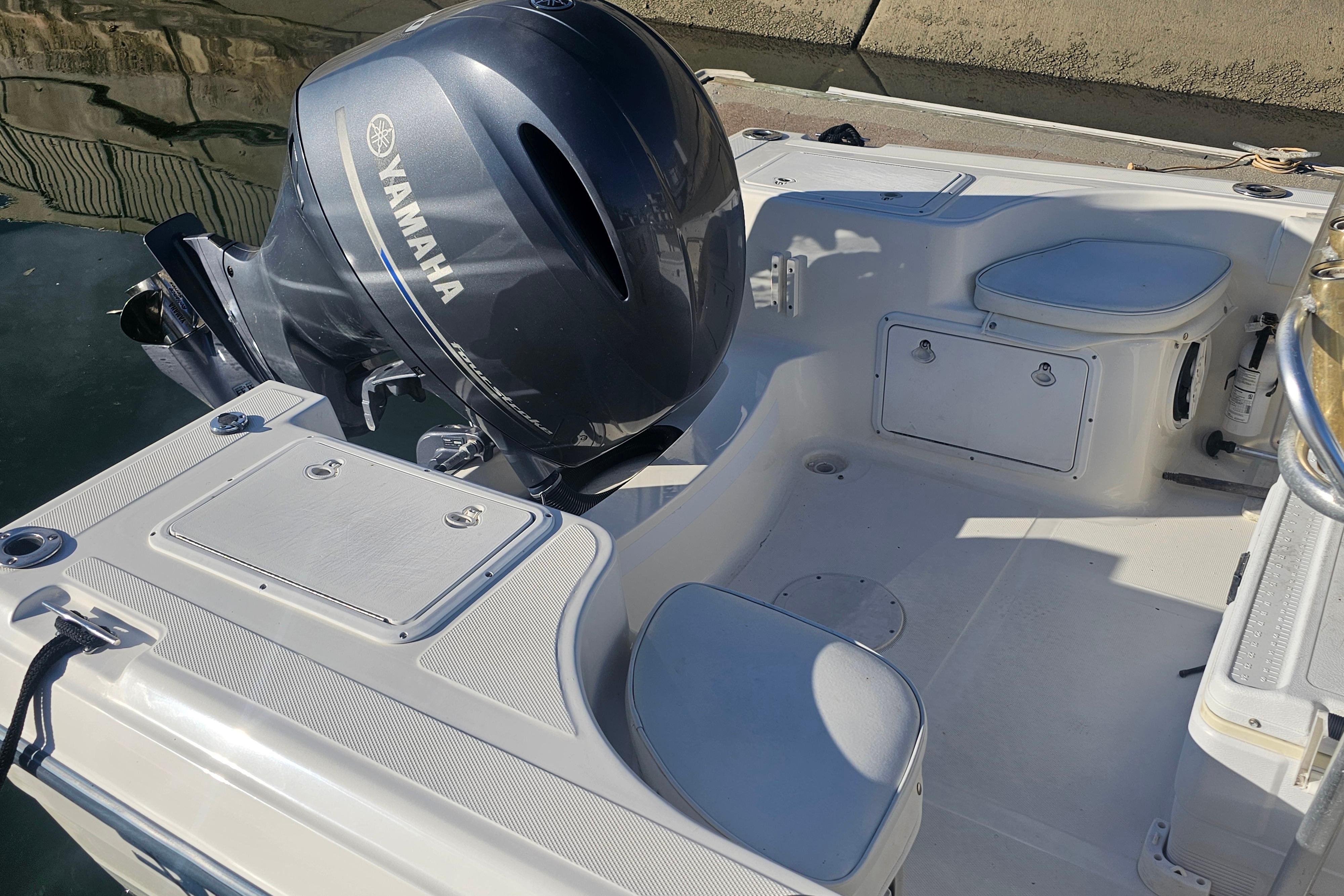 2002 Sea Fox 210 Center Console boat with Yamaha outboard motor, docked in sunlight.
