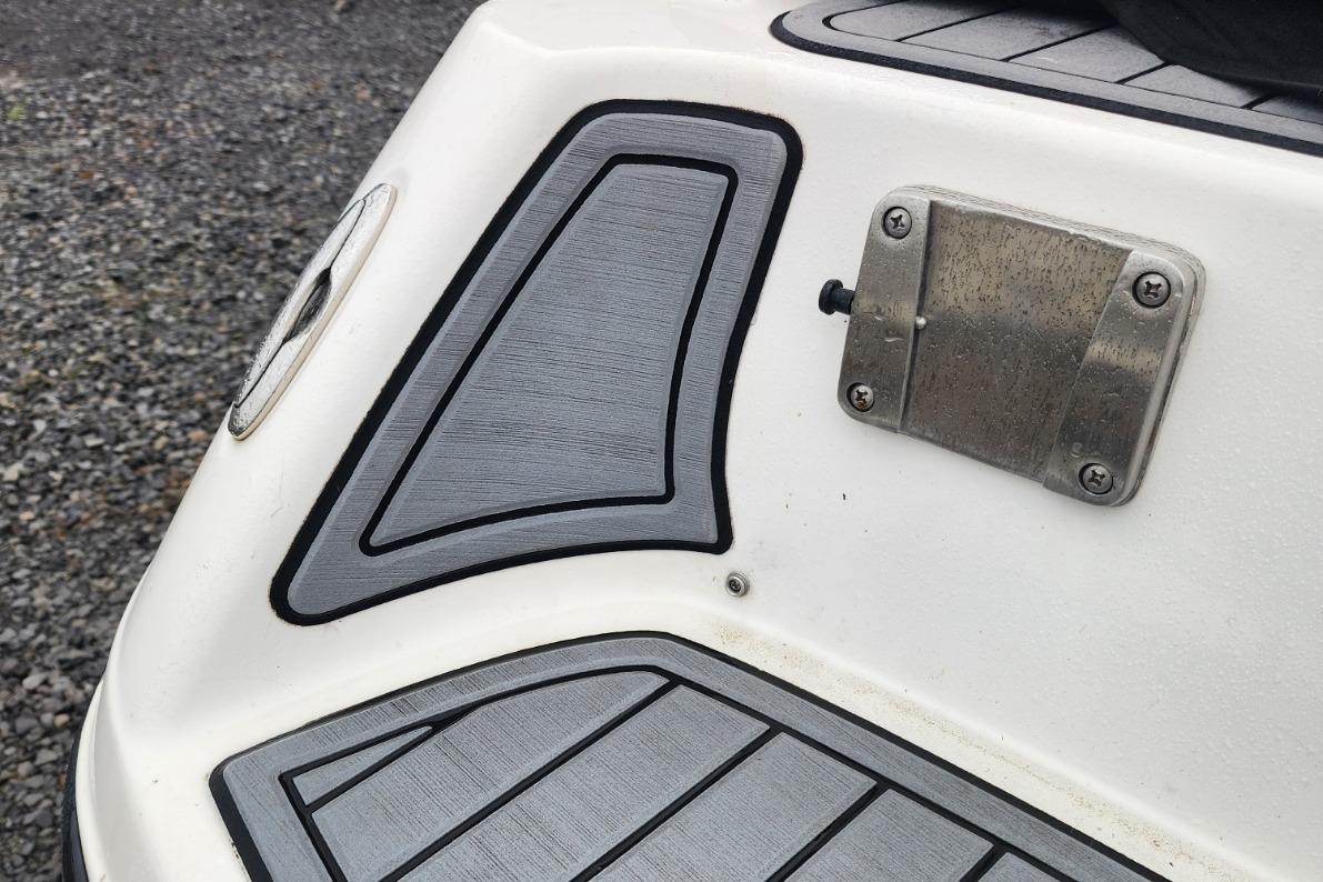 2015 Yamaha Boats 212X swim platform with textured gray padding and metal fixture.