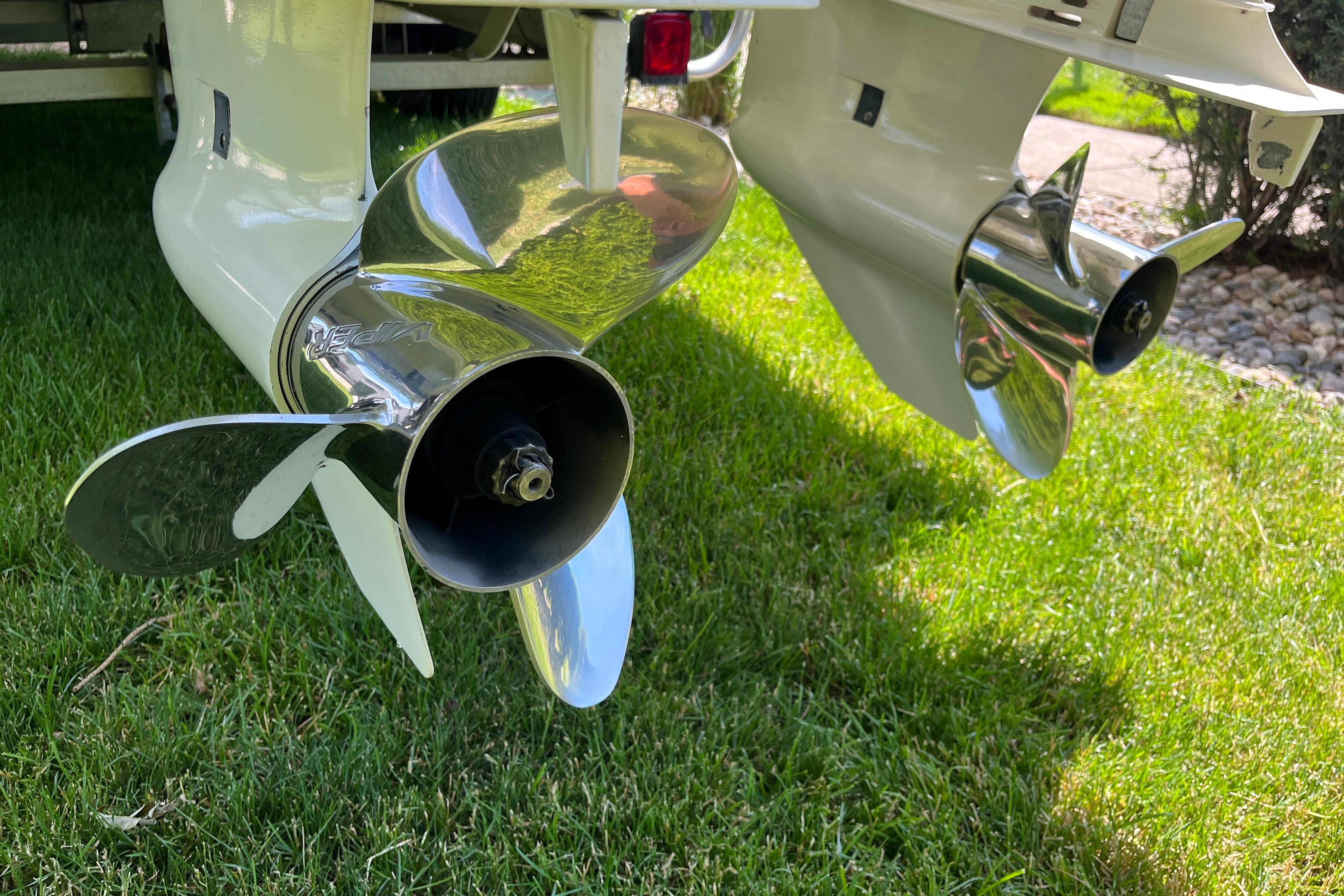 Propellers of a 1994 Intrepid 30 Open Cuddy boat on grass.