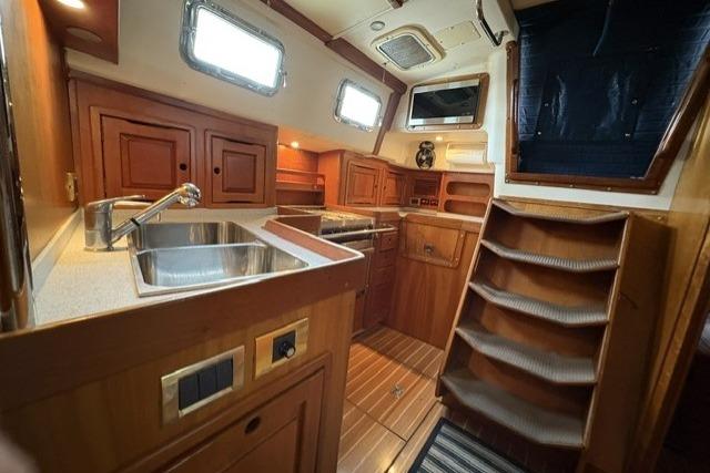 Interior of 2002 Saga 43 yacht with wooden cabinetry and stainless steel sink.