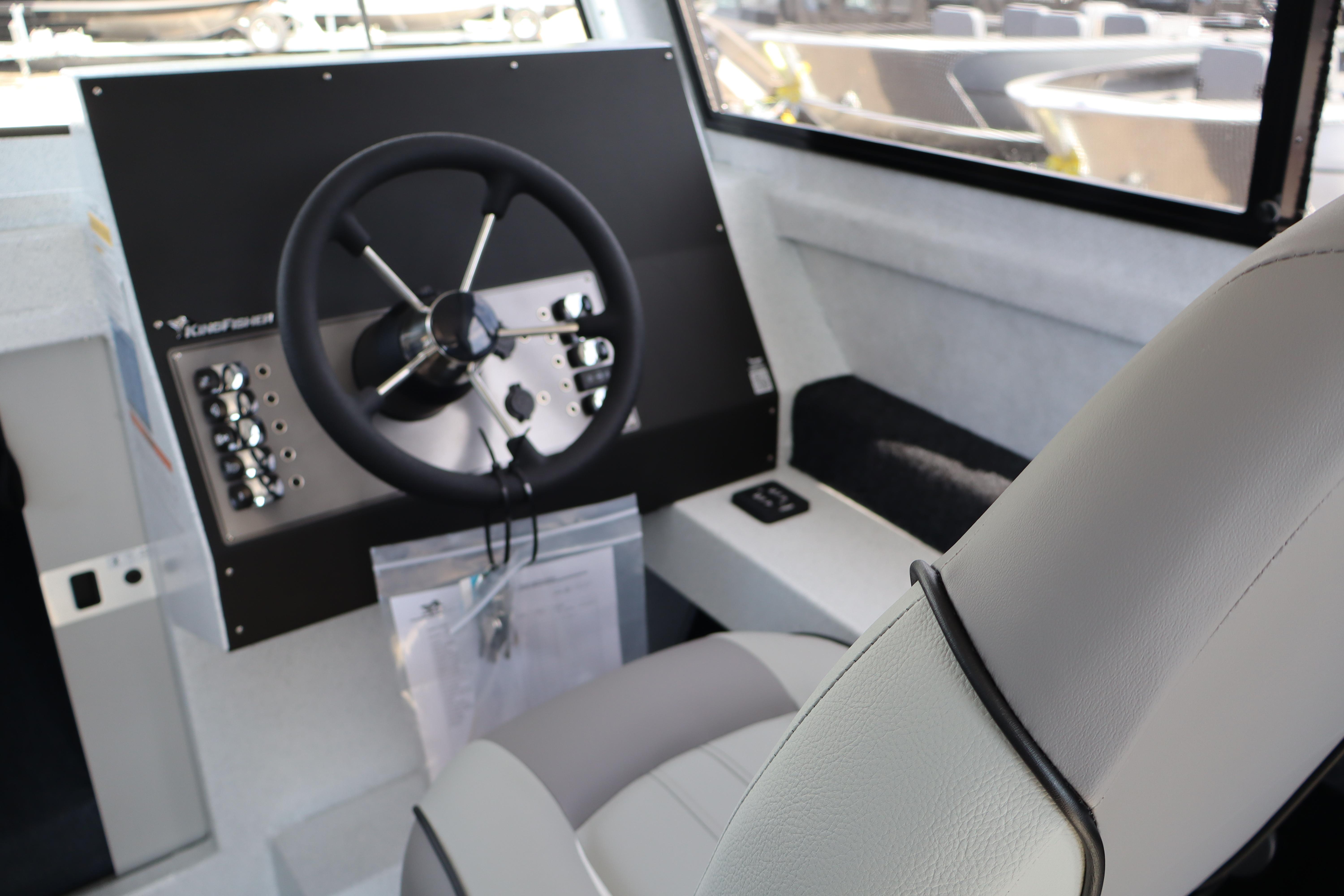 Interior of 2026 KingFisher 25 XAC boat showing steering wheel and control panel.