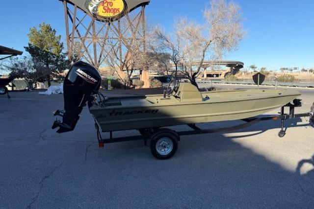 2026 Tracker Grizzly 1648 SC boat on trailer, parked outdoors near Pro Shops sign.