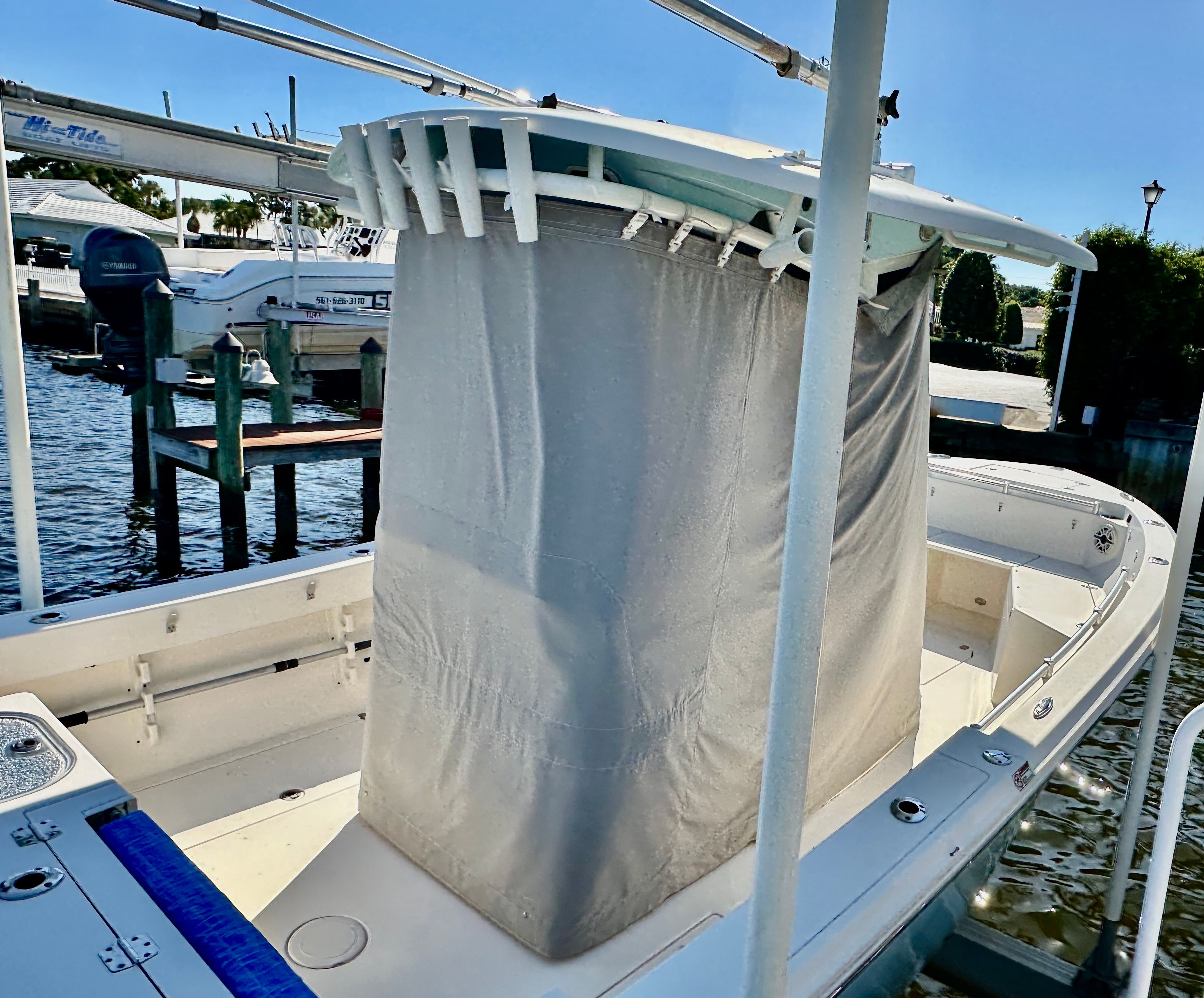 A 2022 Cobia 240 Center Console boat docked. It features a cover over the console.