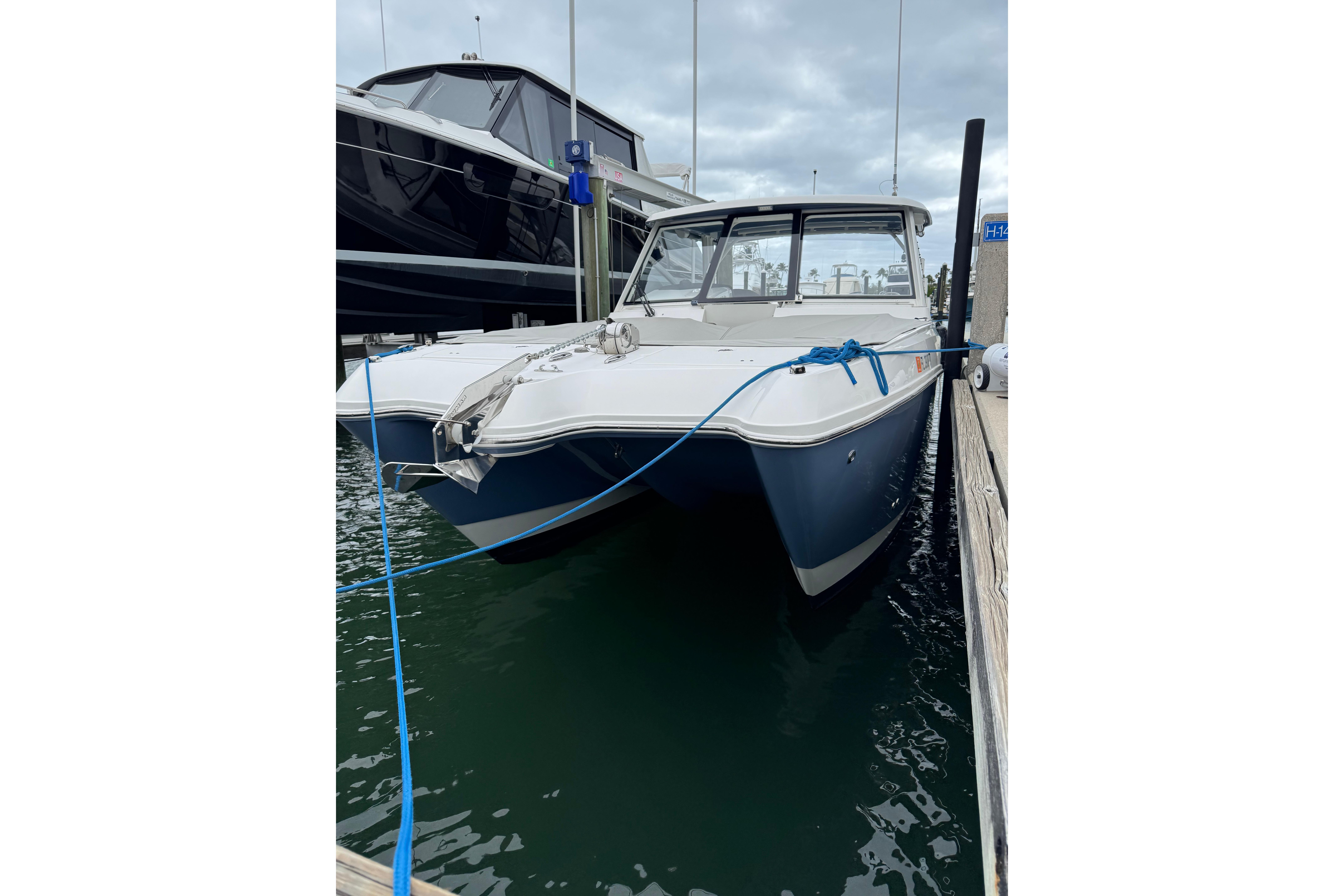 2022 World Cat 325 DC boat docked in marina, front view.