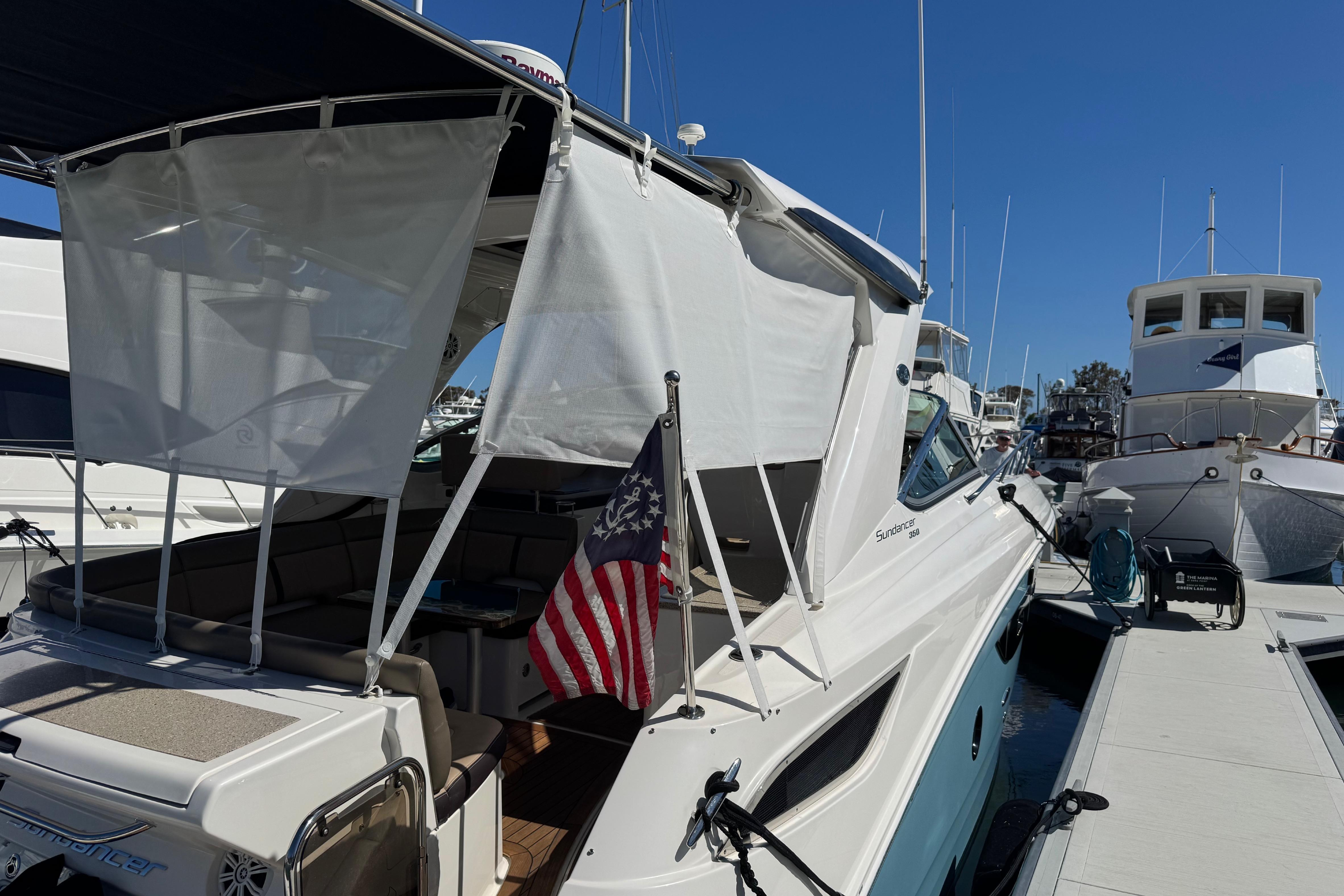 2016 Sea Ray Sundancer 350 docked, featuring a shaded seating area and American flag.